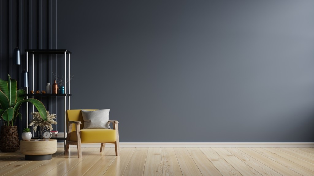 Yellow armchair in a minimalist living room with dark blue wall.