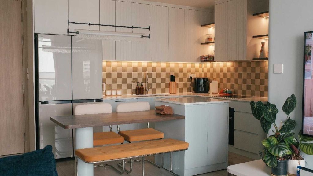 Apartment kitchen with dining area, featuring a bench and pendant lights