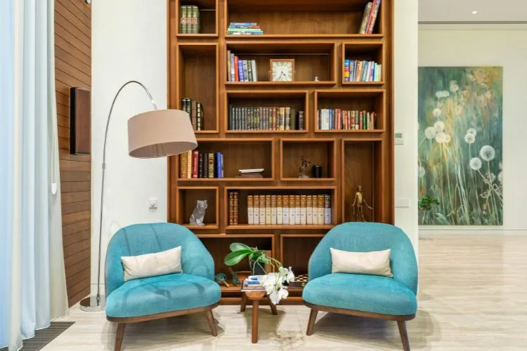 stylish reading nook featuring a warm wooden bookshelf filled with books and decorative pieces, a cozy floor lamp