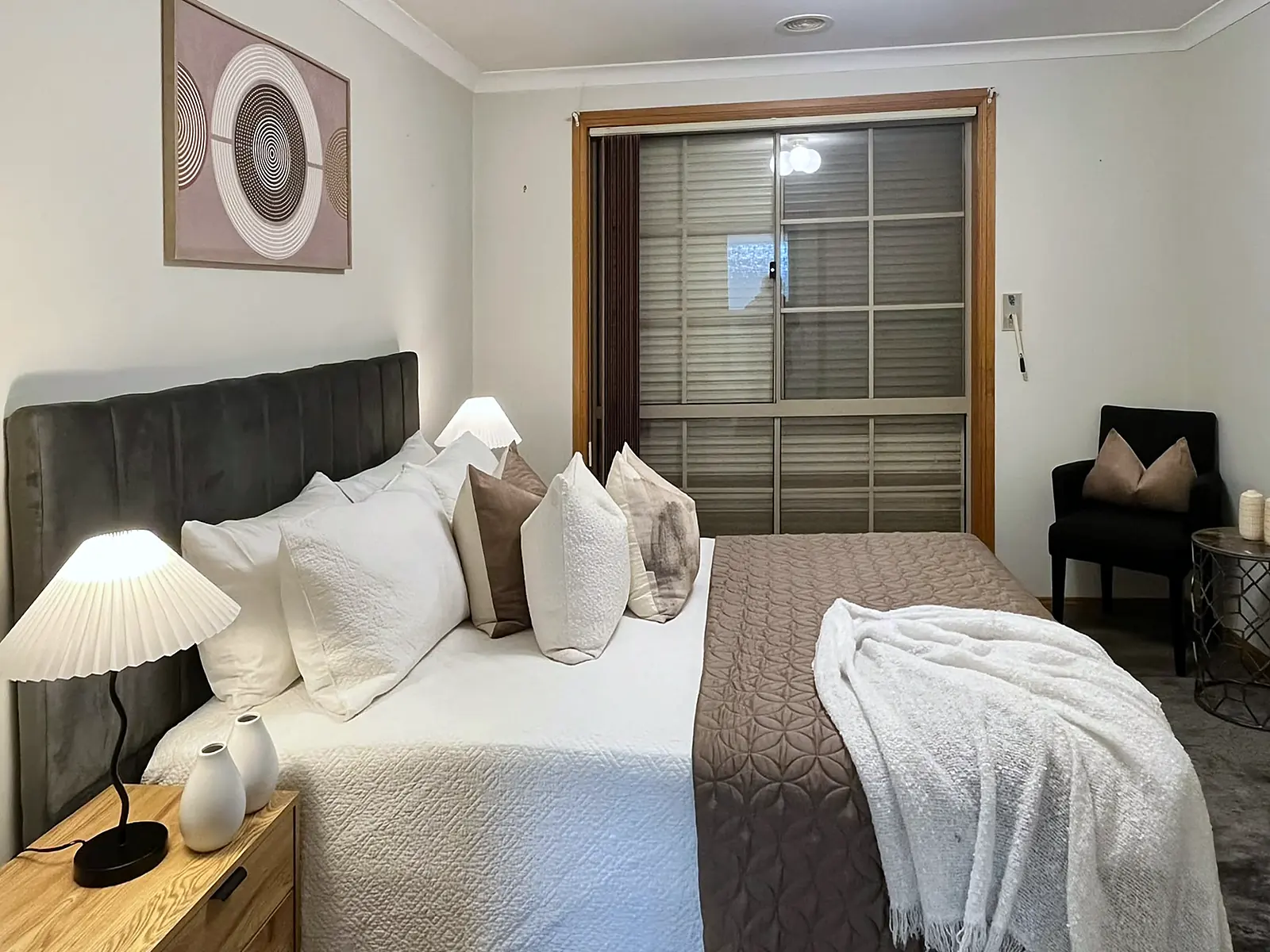 Main bedroom staged with dark bedhead and textured throw in an Altona Meadows home