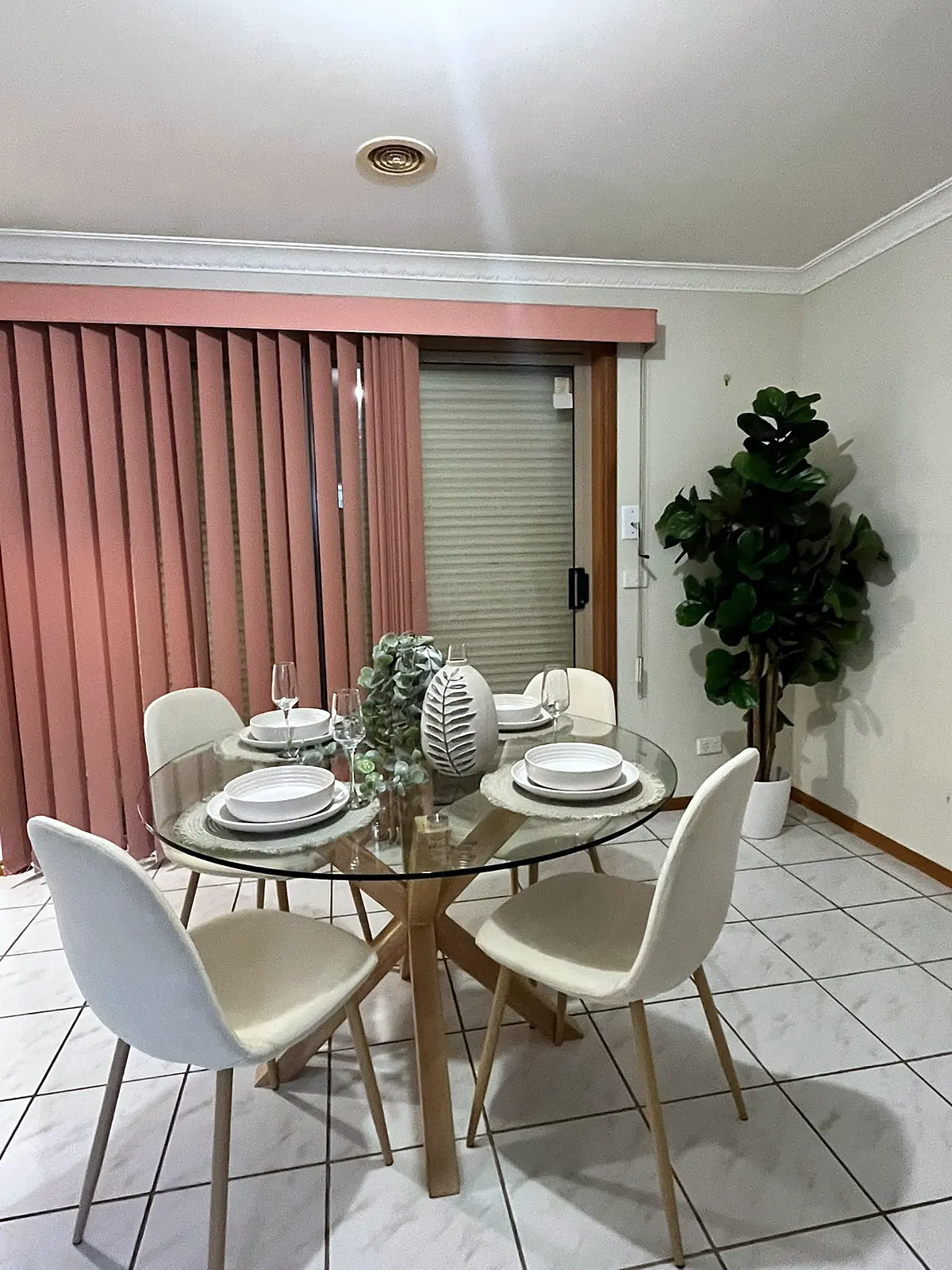 Round glass dining table in a staged Altona Meadows meals area
