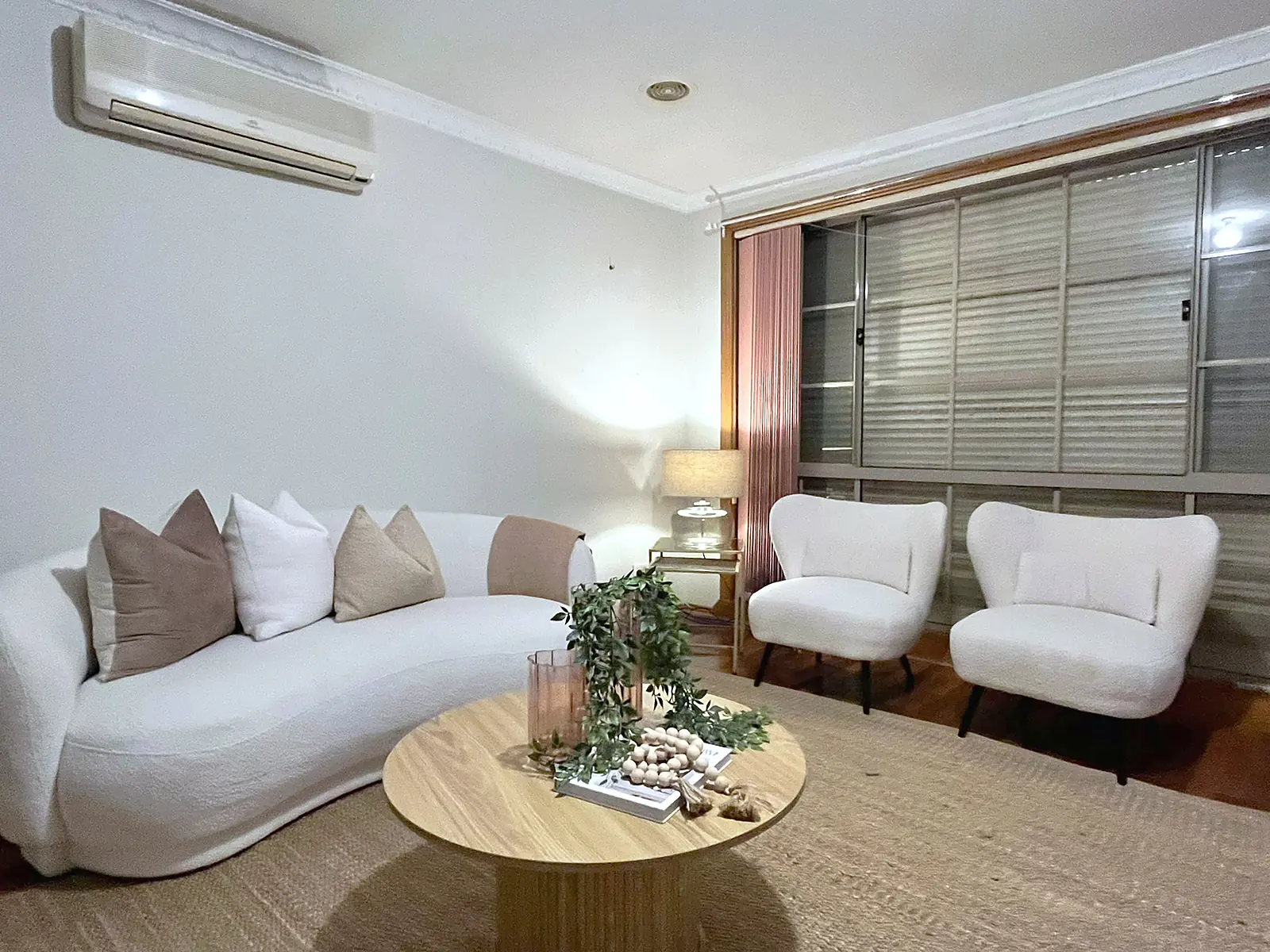 Living room styled with boucle armchairs and round coffee table in an Altona Meadows home