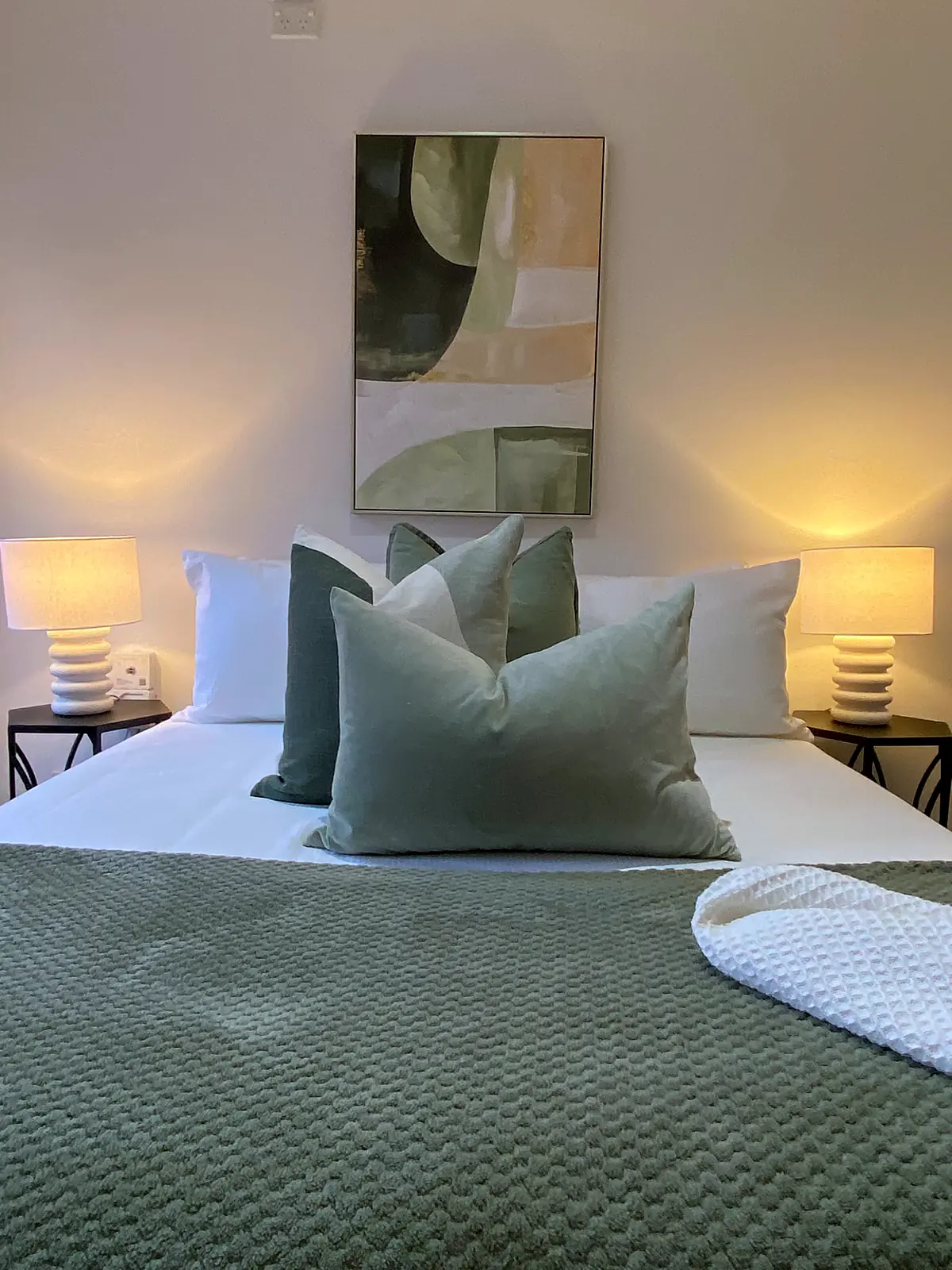 Bedroom styled with sage green linen and lamps in an Altona North unit