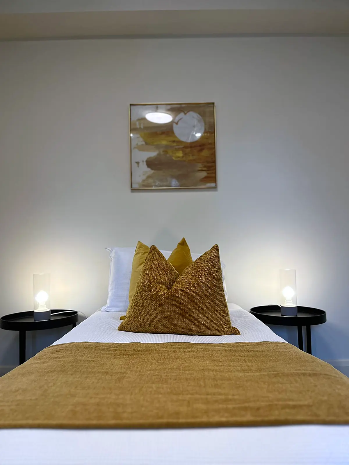 Bedroom styled with mustard cushions and throw in a Balwyn home