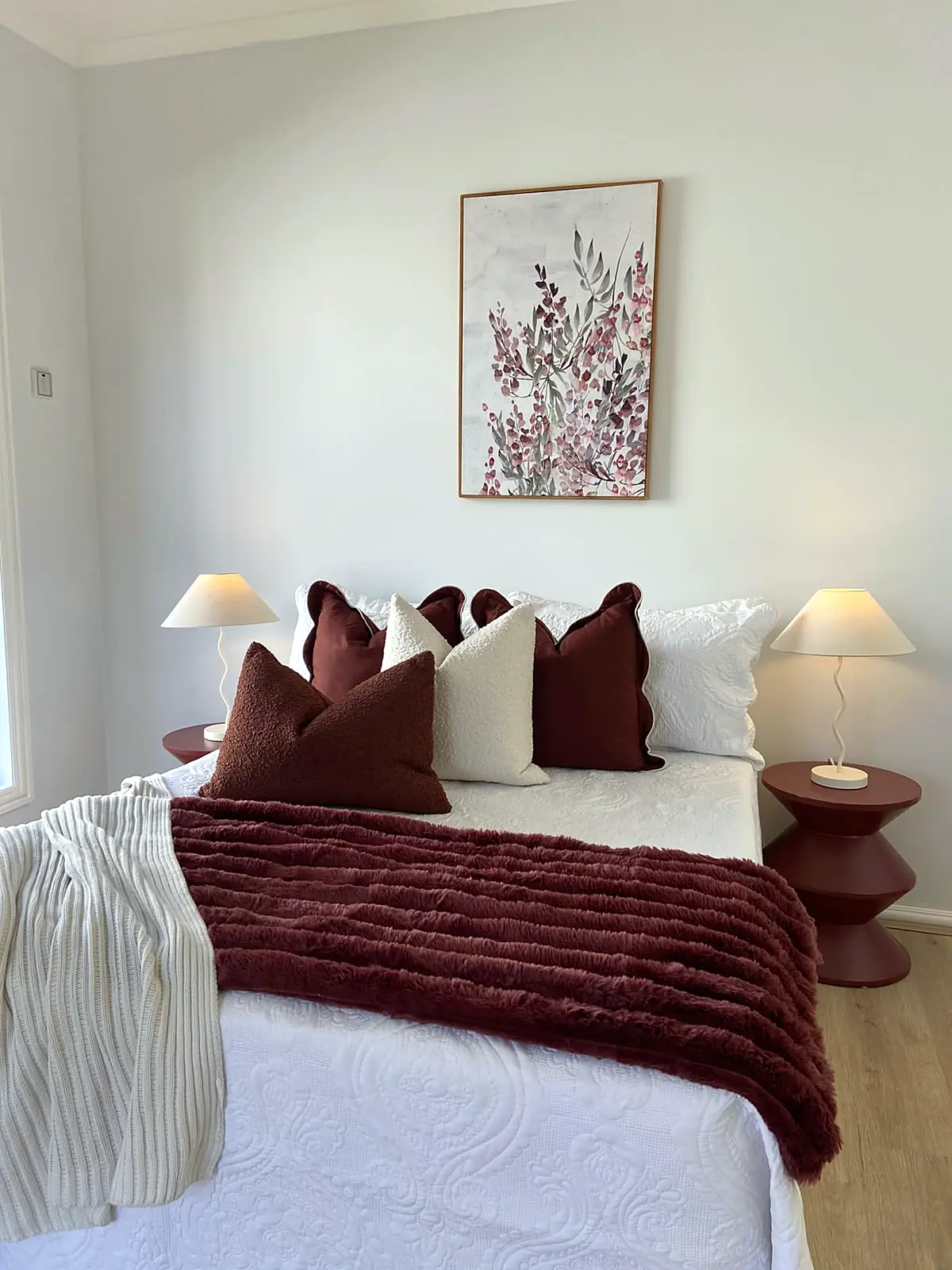 Bedroom styled with burgundy cushions and throw in a Braybrook home