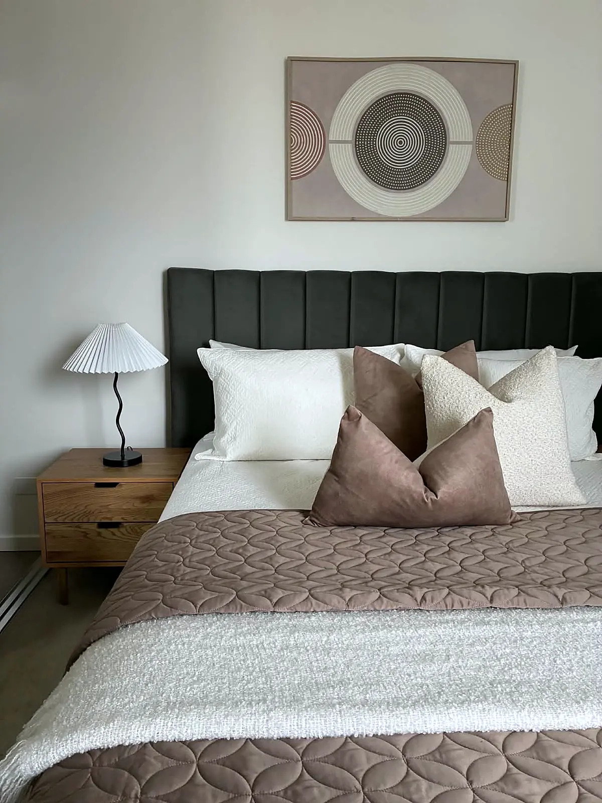 Apartment bedroom styled with dark bedhead and mauve quilt in Brunswick