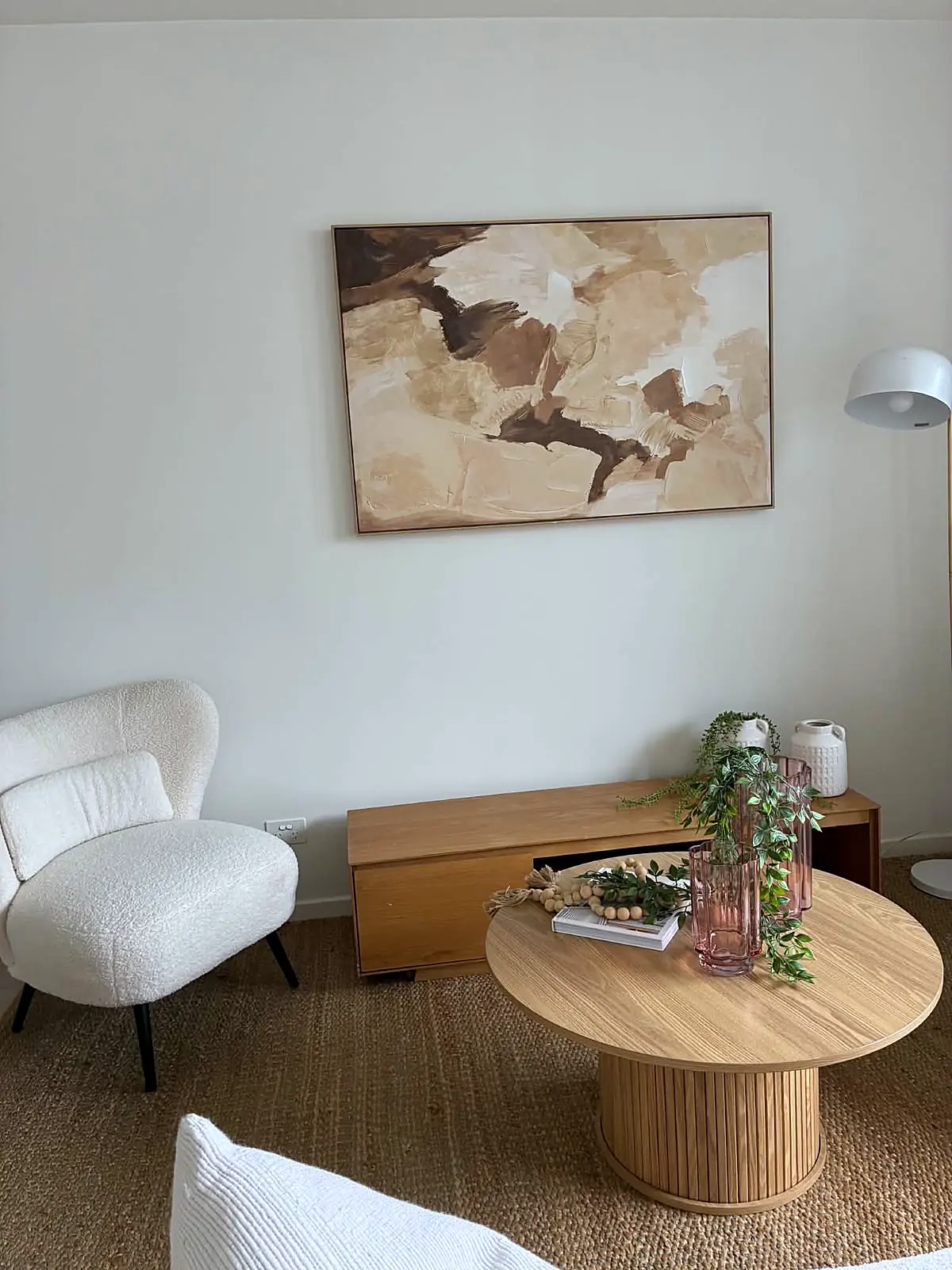 Staged apartment living room with boucle armchair and round coffee table in Brunswick