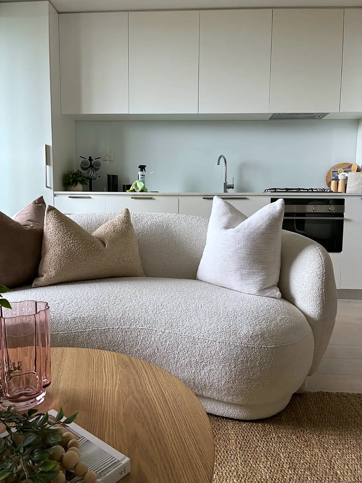 Curved boucle sofa in an open-plan Brunswick apartment staged for sale