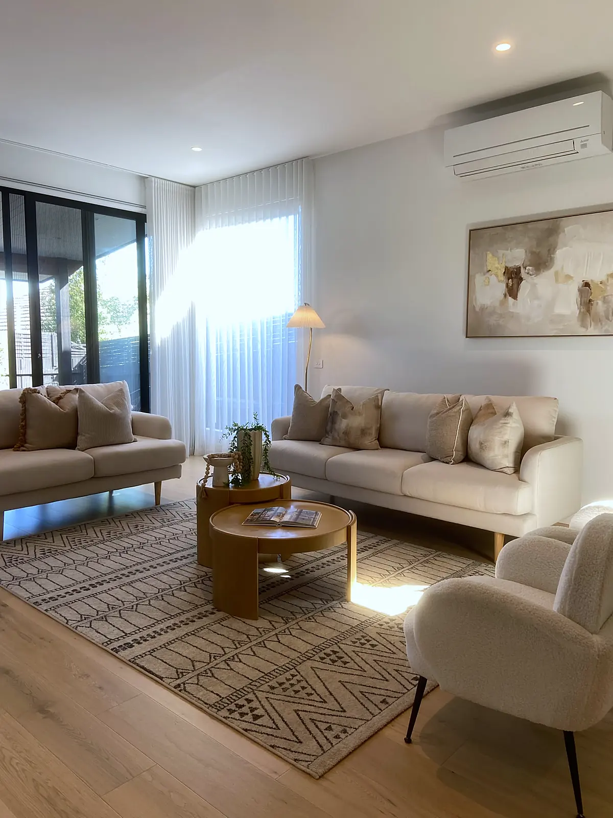 Living room staged with cream sofas and patterned rug in a luxury Bulleen home