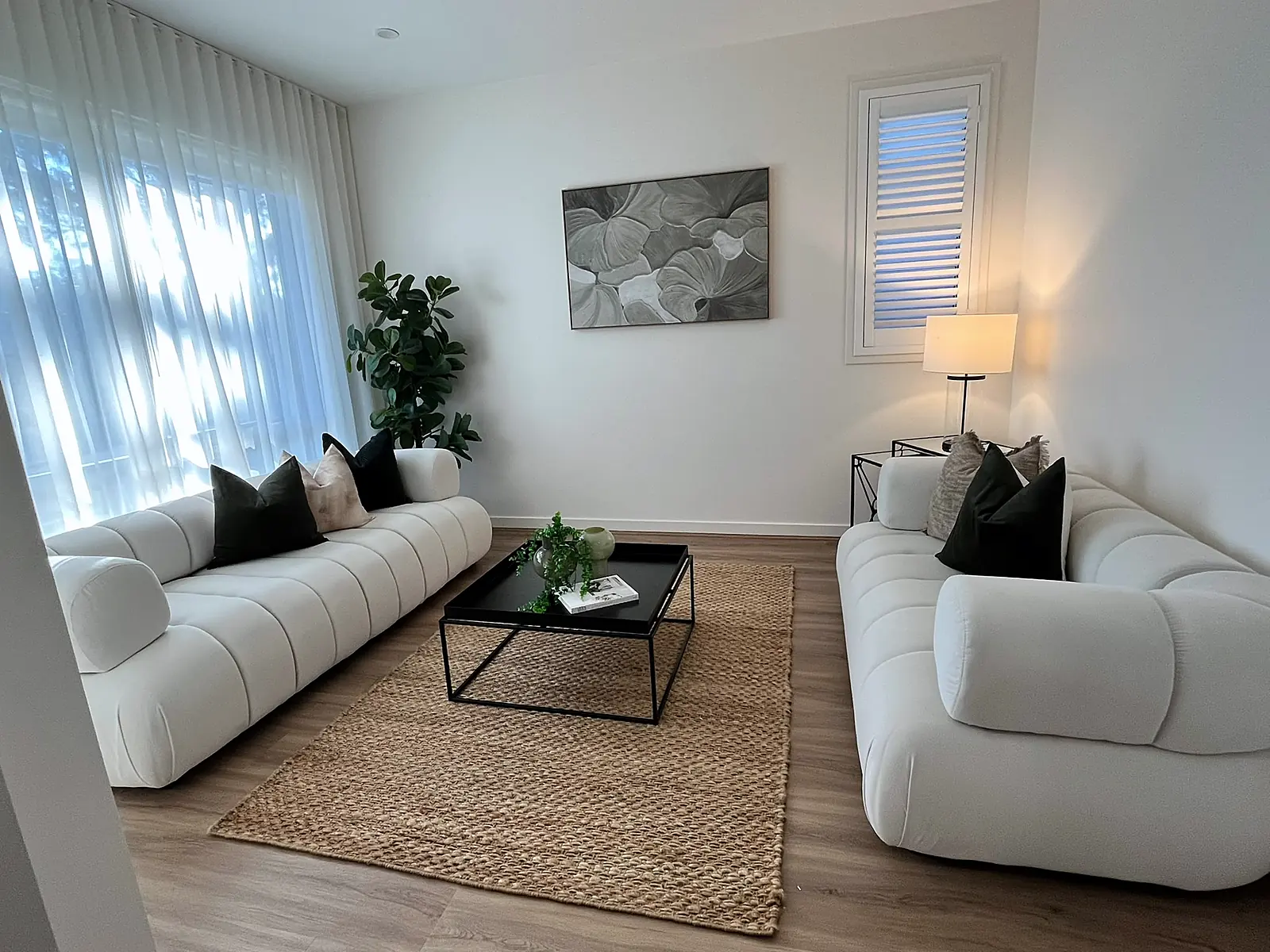Living room staged with white channelled sofas and jute rug in a Bundoora home