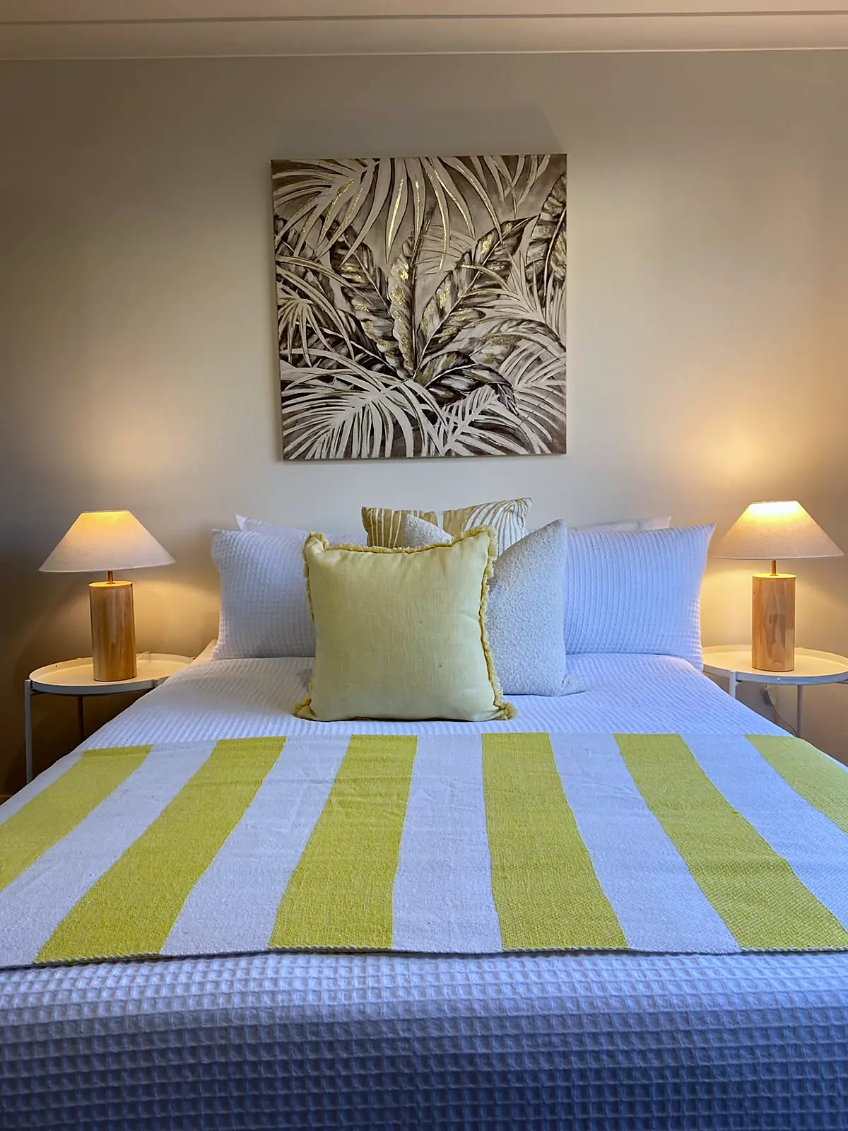 Bedroom styled with yellow striped throw and botanical artwork in a Burnside Heights home