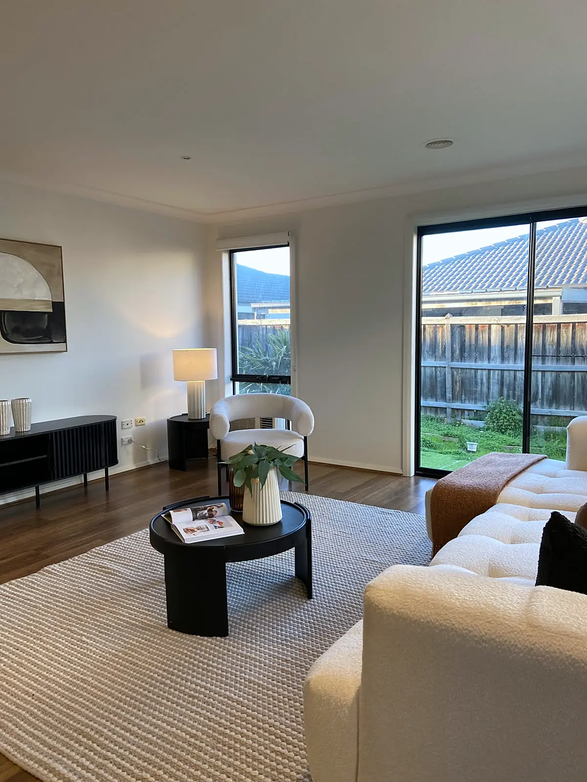 Open-plan living area with armchair and sideboard staged in a Burnside Heights home