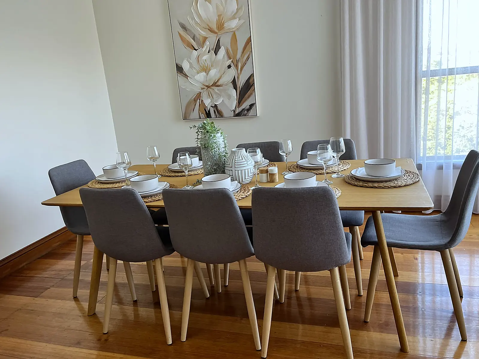 Dining room staged with timber table and grey chairs in a Chadstone home