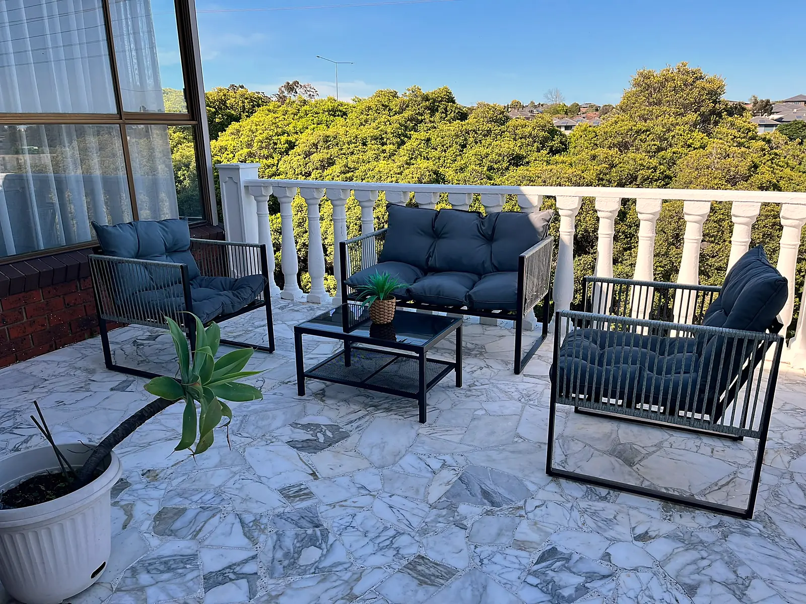 Balcony styled with outdoor lounge overlooking treetops in Chadstone