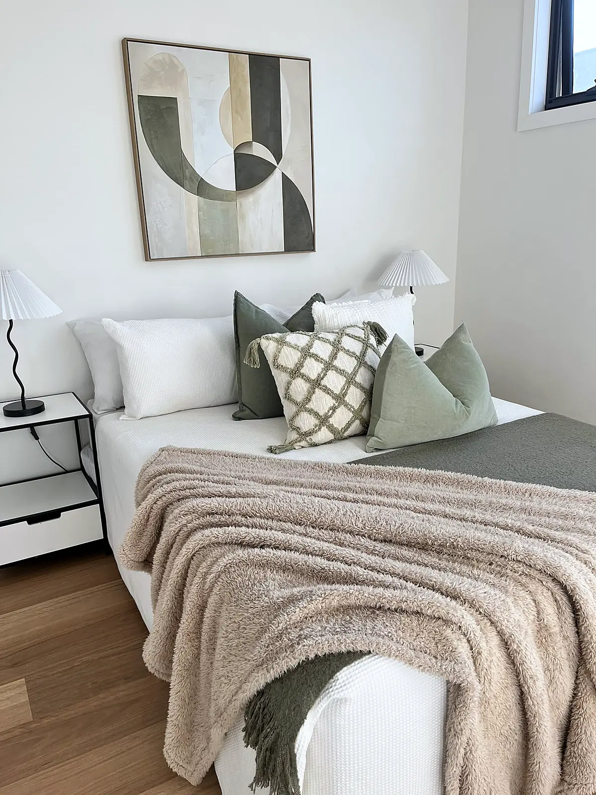 Bedroom styled with sage cushions and textured throw in a Craigieburn home
