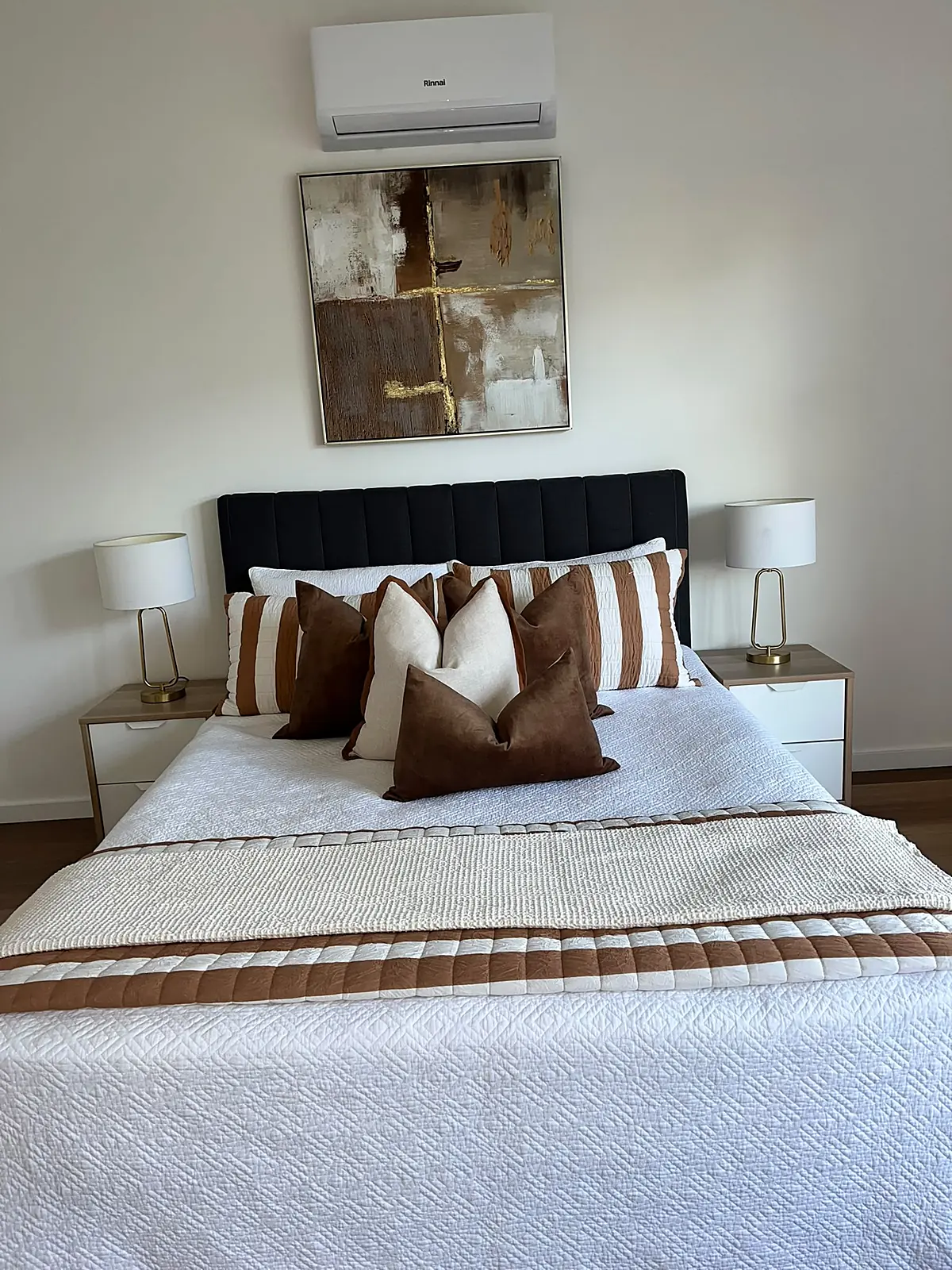 Master bedroom styled with dark bedhead and tan cushions in Craigieburn