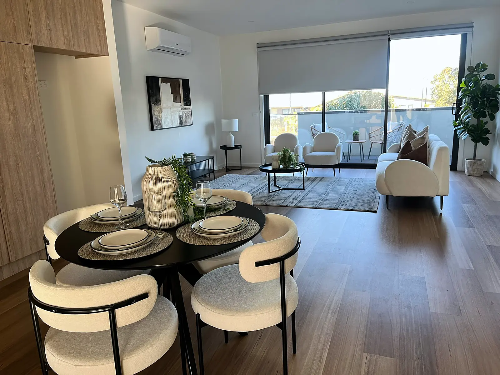 Open-plan dining and living staged with round black table in a Craigieburn home