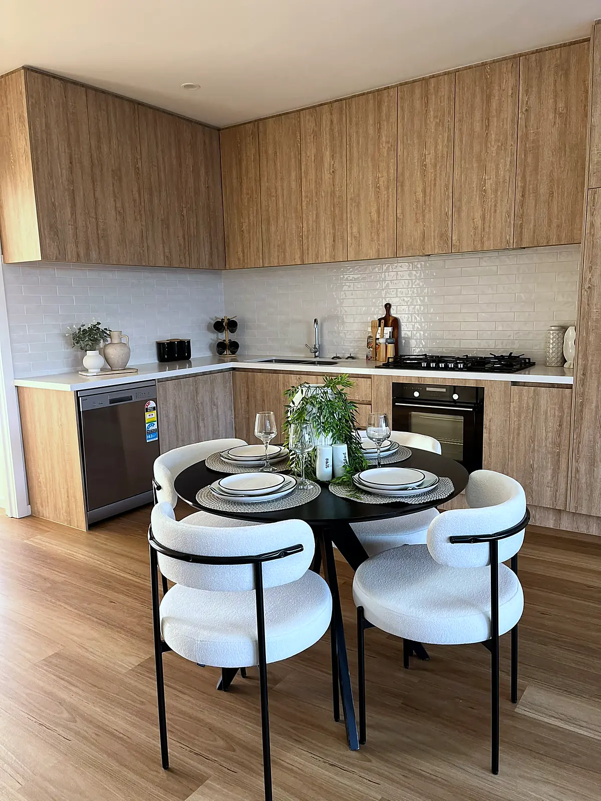 Timber-look kitchen with round dining setting in a staged Craigieburn home