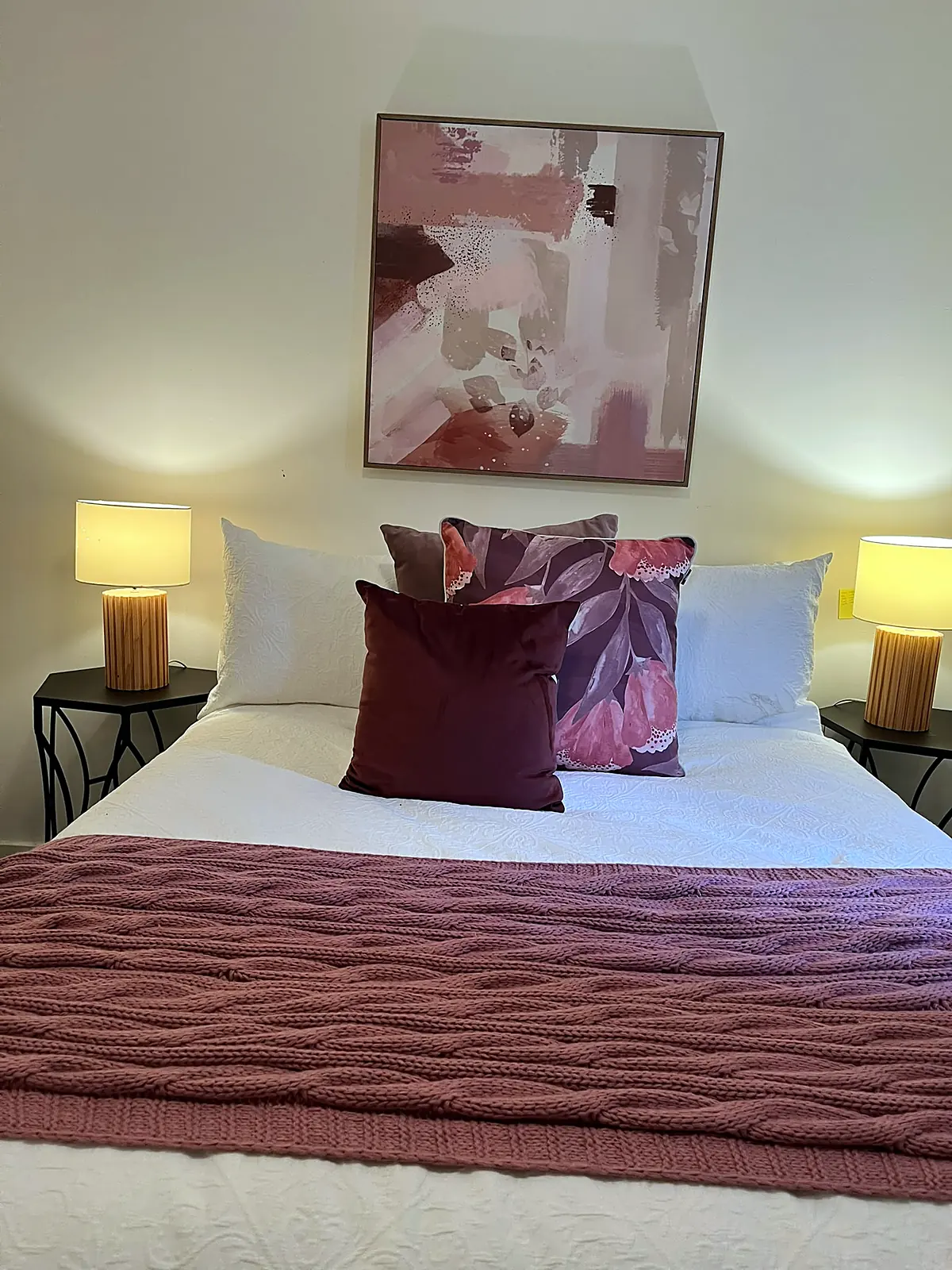 Bedroom styled with plum linen and artwork in a Deer Park home