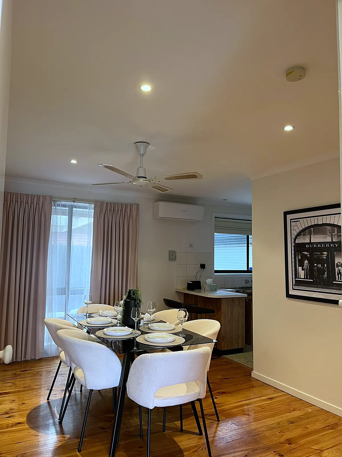 Dining room with timber floor staged with white chairs in a Deer Park home