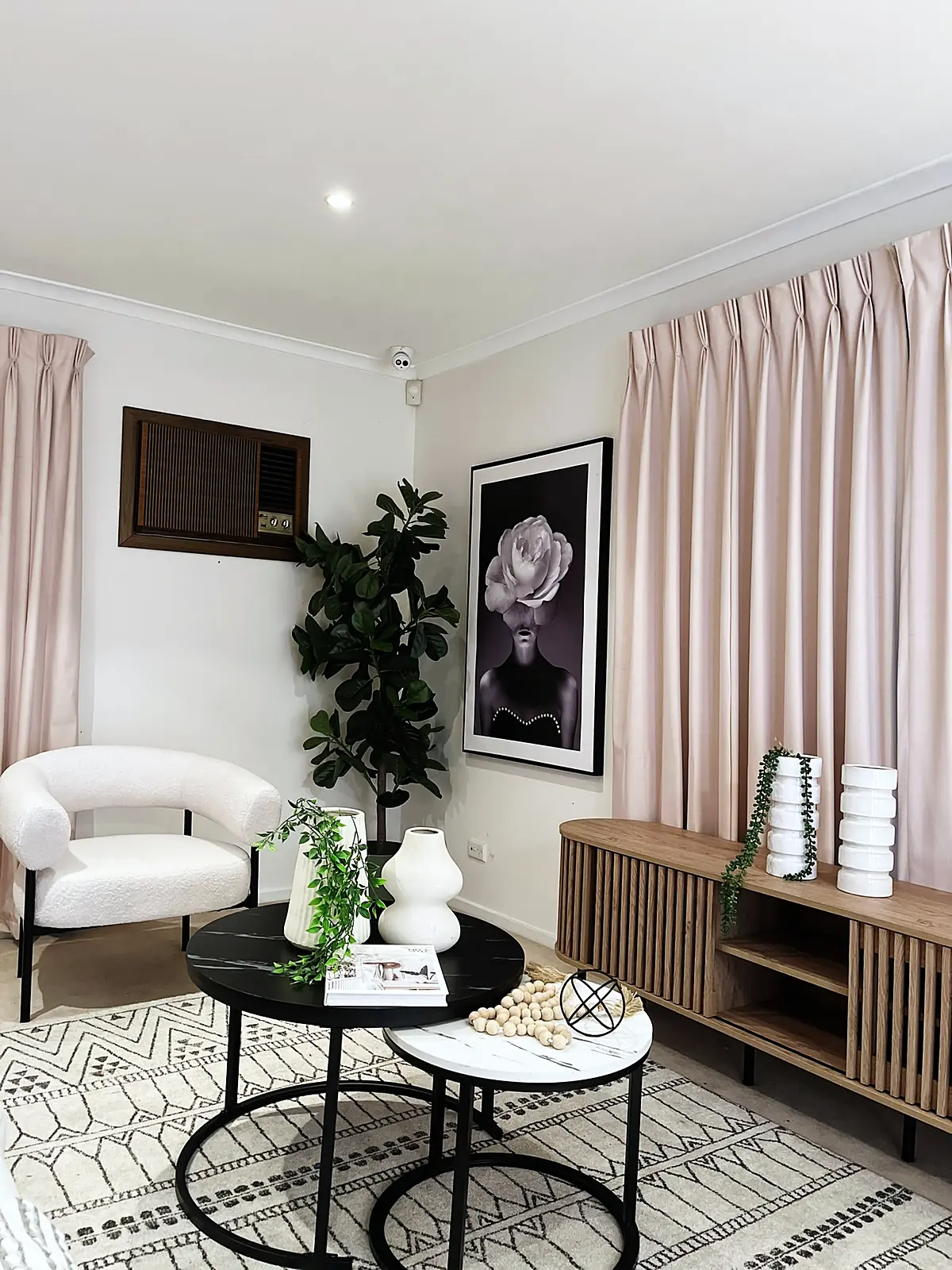 Living room styled with black coffee tables and boucle armchair in a Deer Park home