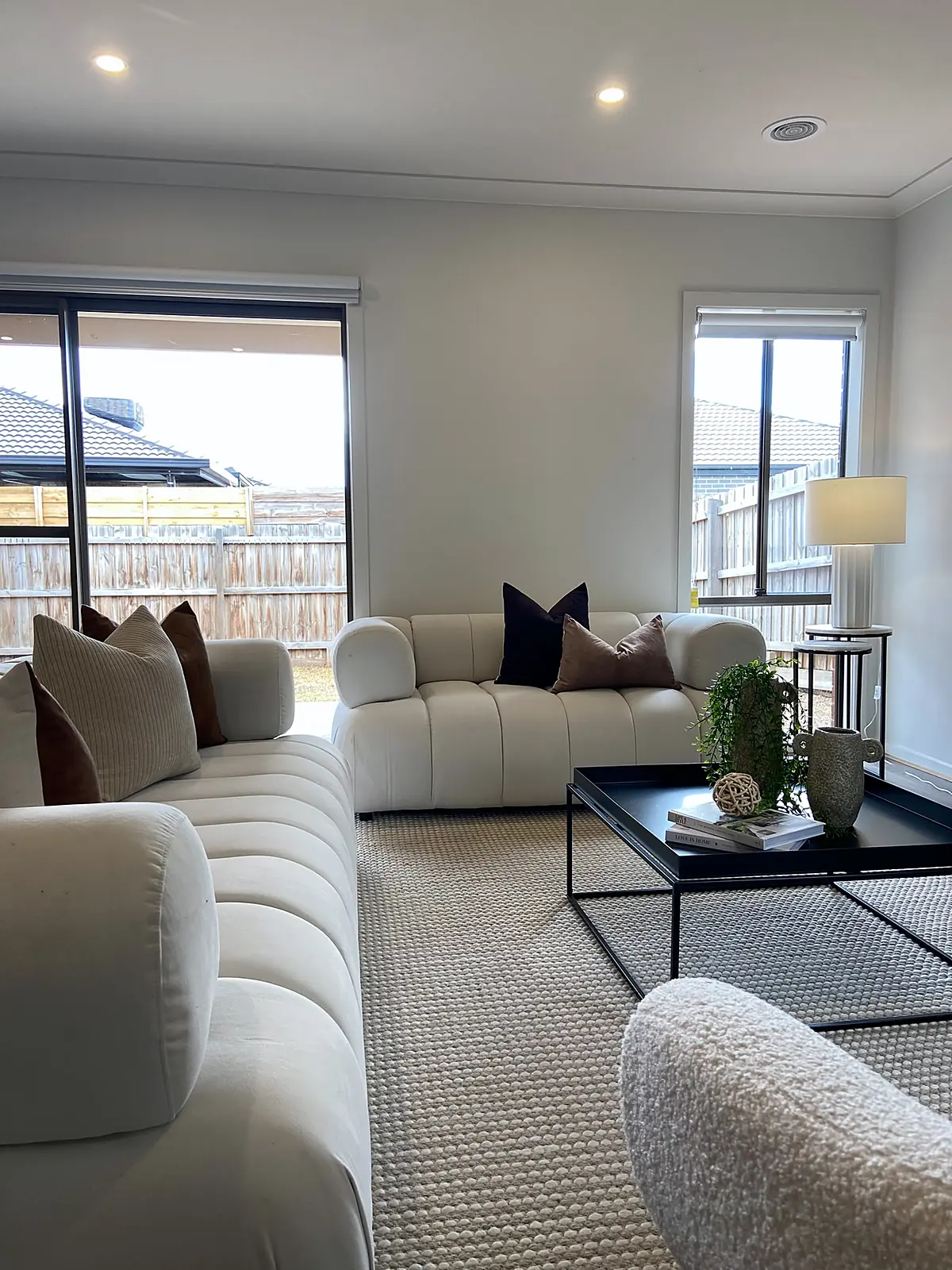 Open-plan lounge with channelled sofas and coffee table staged in a Diggers Rest home