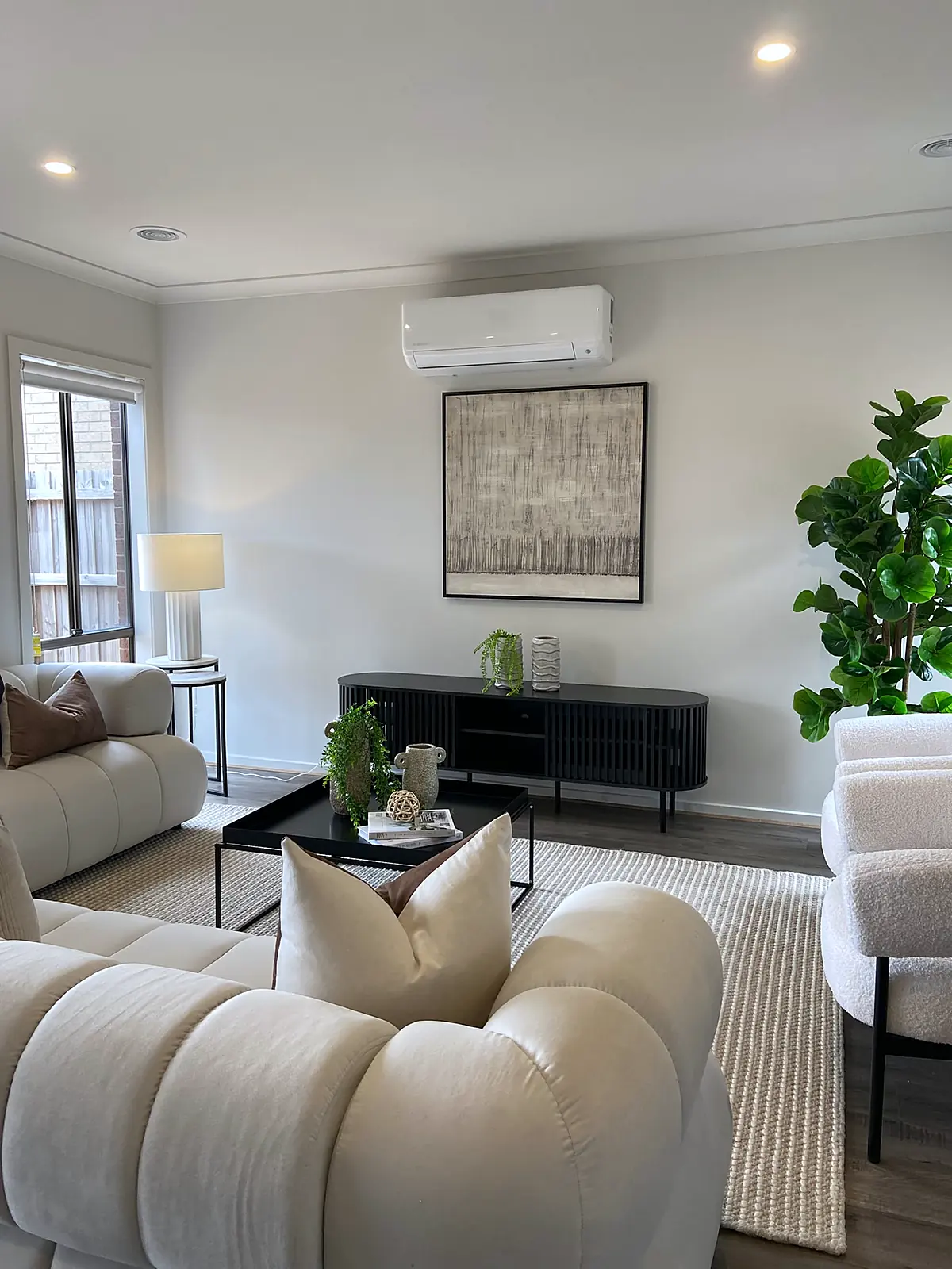 Living room staged with cream sofas and black sideboard in a Diggers Rest home