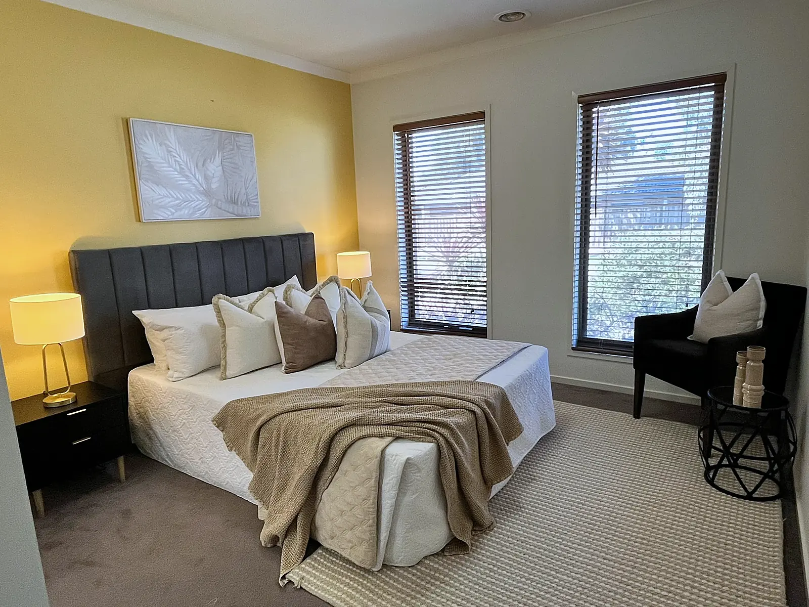 Main bedroom with yellow feature wall staged in neutral linen in a Doreen home