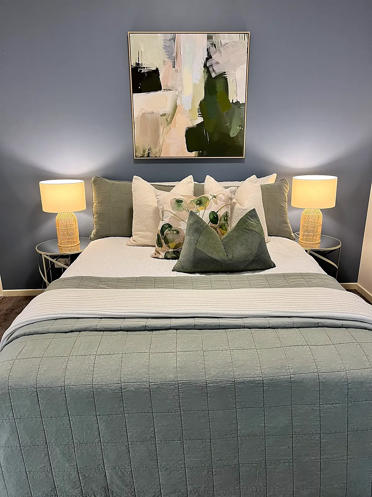 Bedroom with blue-grey wall styled in green and white linen in a Doreen home