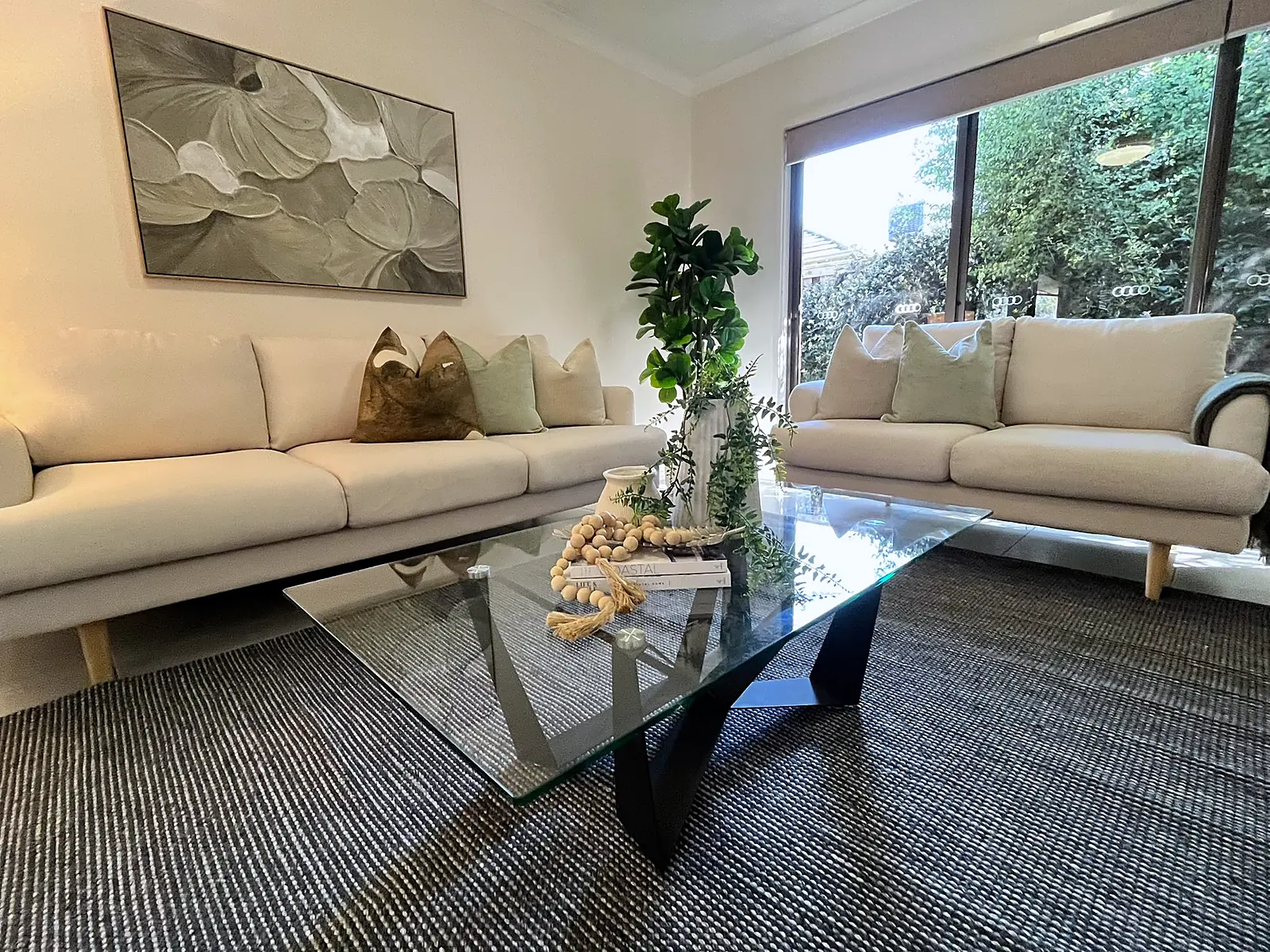 Lounge with glass coffee table and garden outlook in a staged Doreen home
