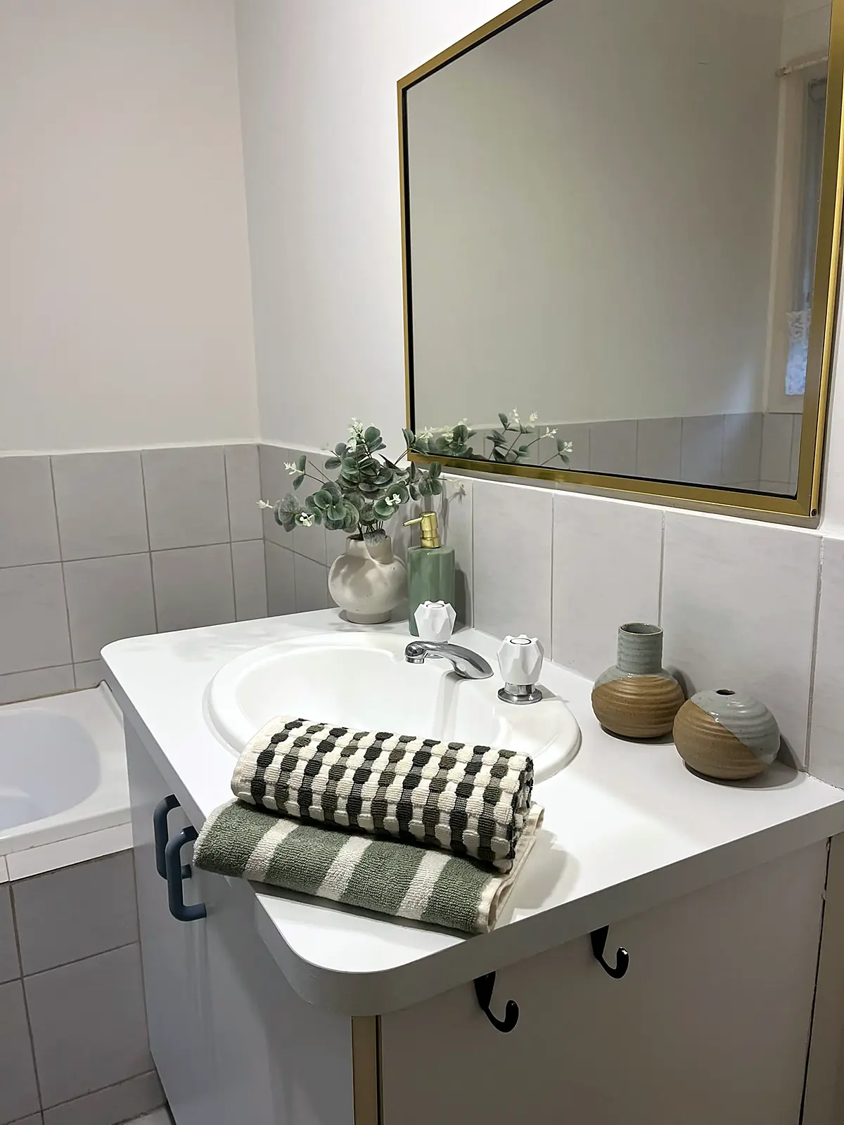 Bathroom vanity styled with towels and greenery in an Epping home