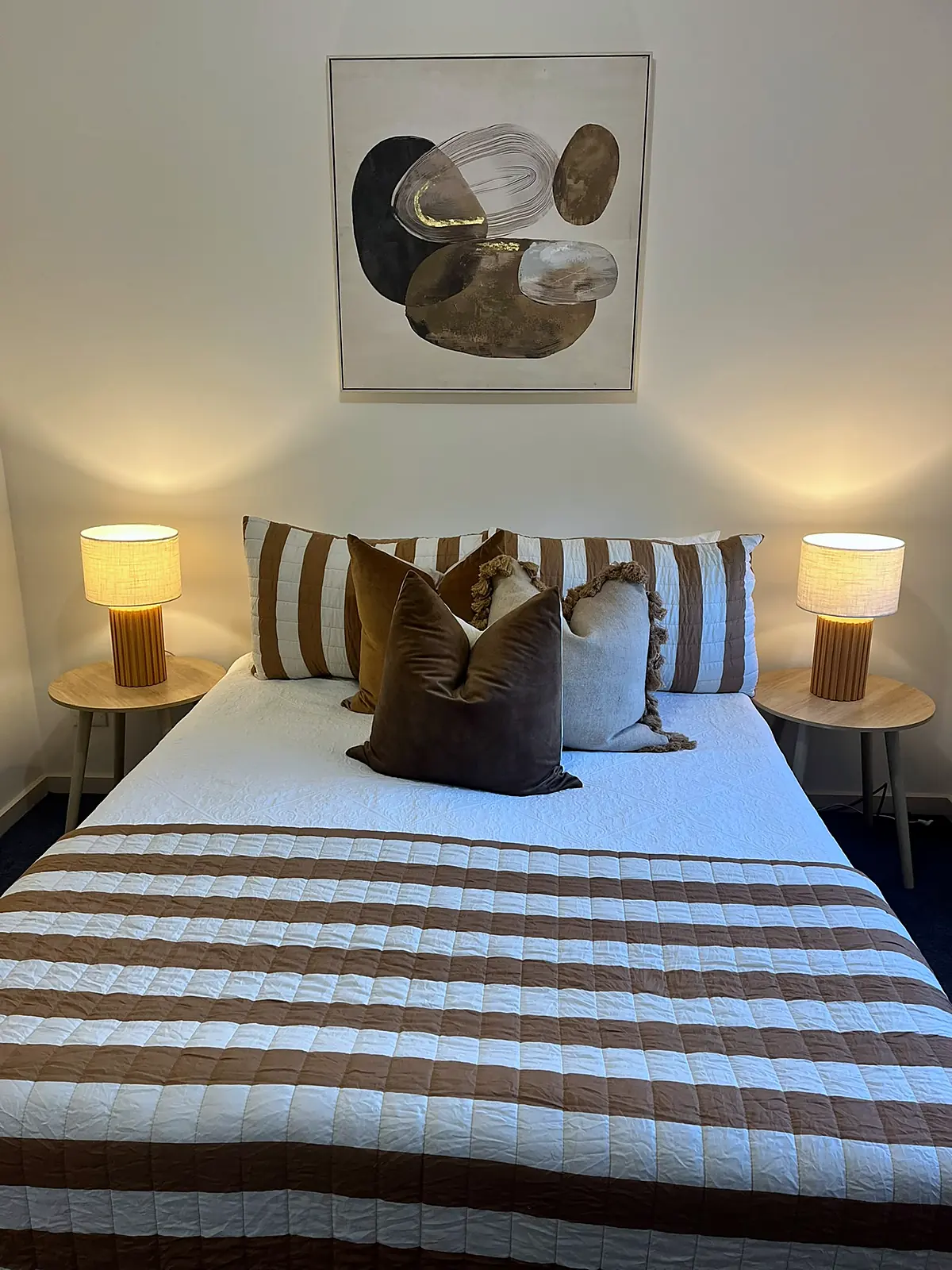 Bedroom styled with striped throw and lamps in an Epping home
