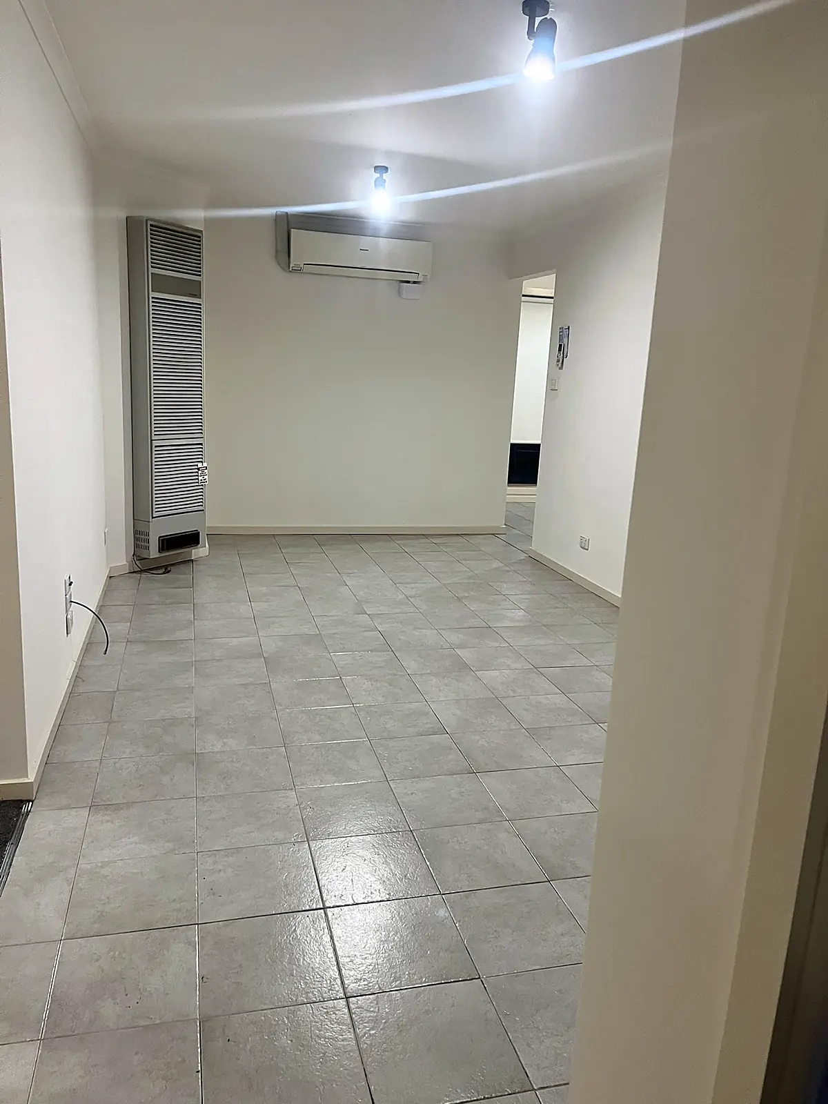 Empty tiled living room before staging in an Epping home