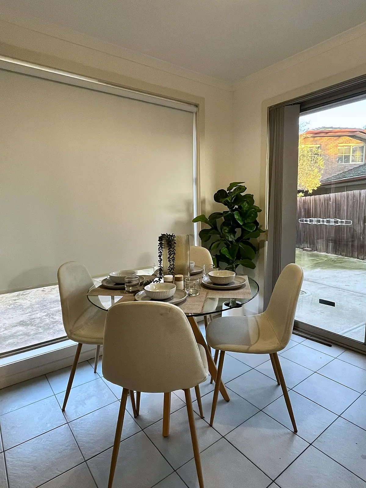 Round glass dining table by the sliding door in a staged Epping home