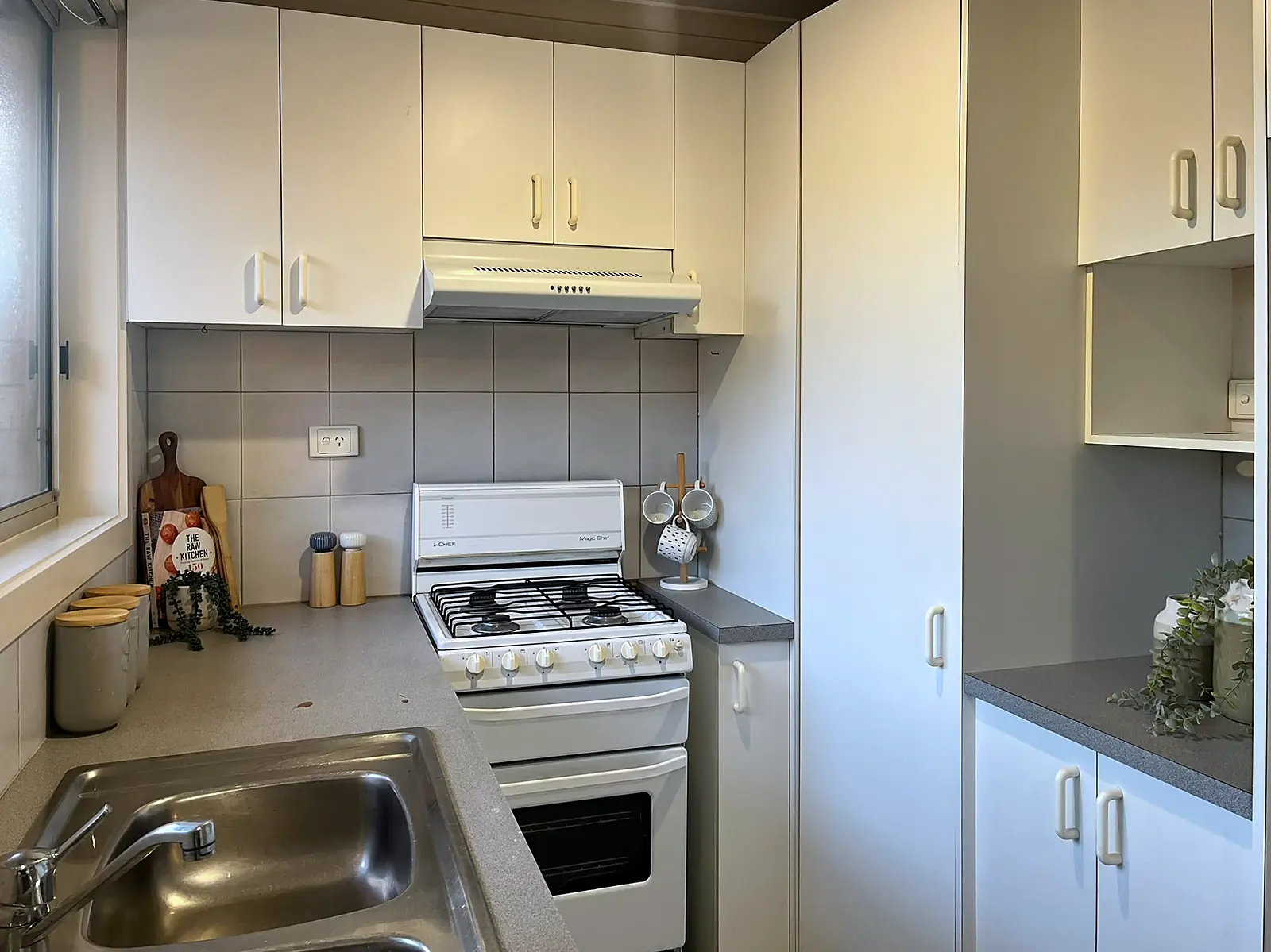 White kitchen styled with boards and canisters in an Epping home
