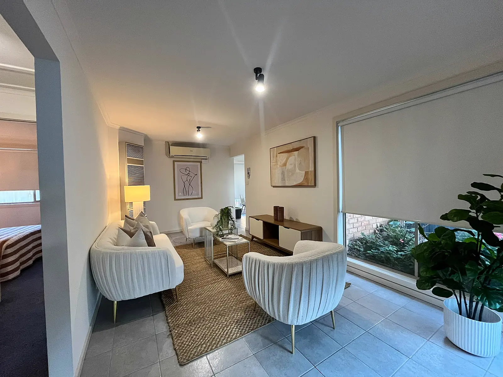 Living room staged with cream armchairs and jute rug in an Epping home