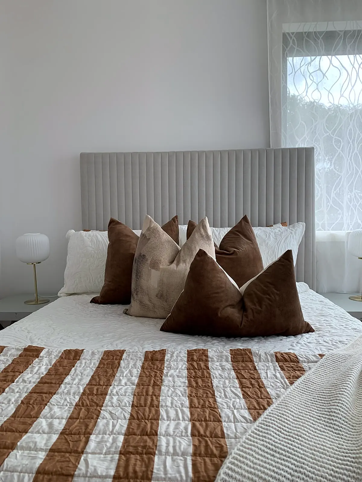 Bedroom staged with rust striped quilt and ribbed bedhead in a Footscray townhouse