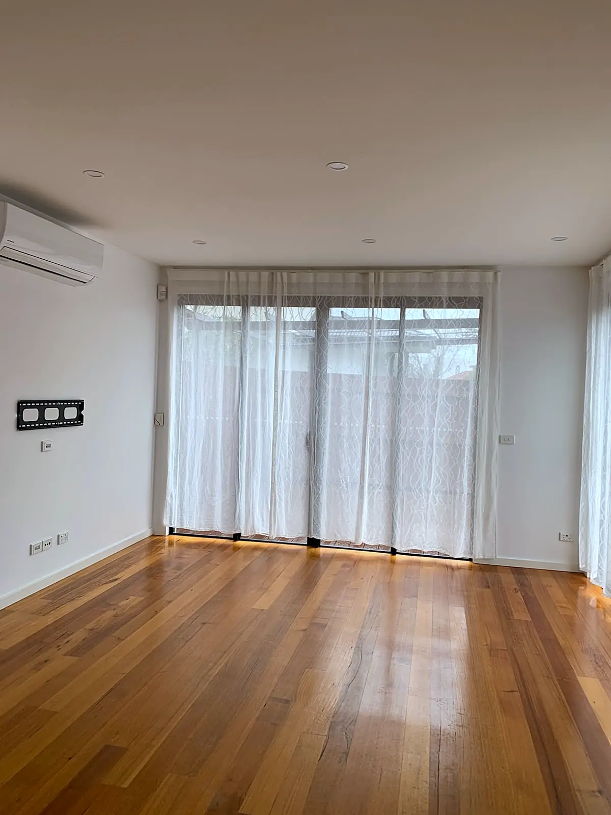Empty living room with polished timber floor before staging in a Footscray townhouse