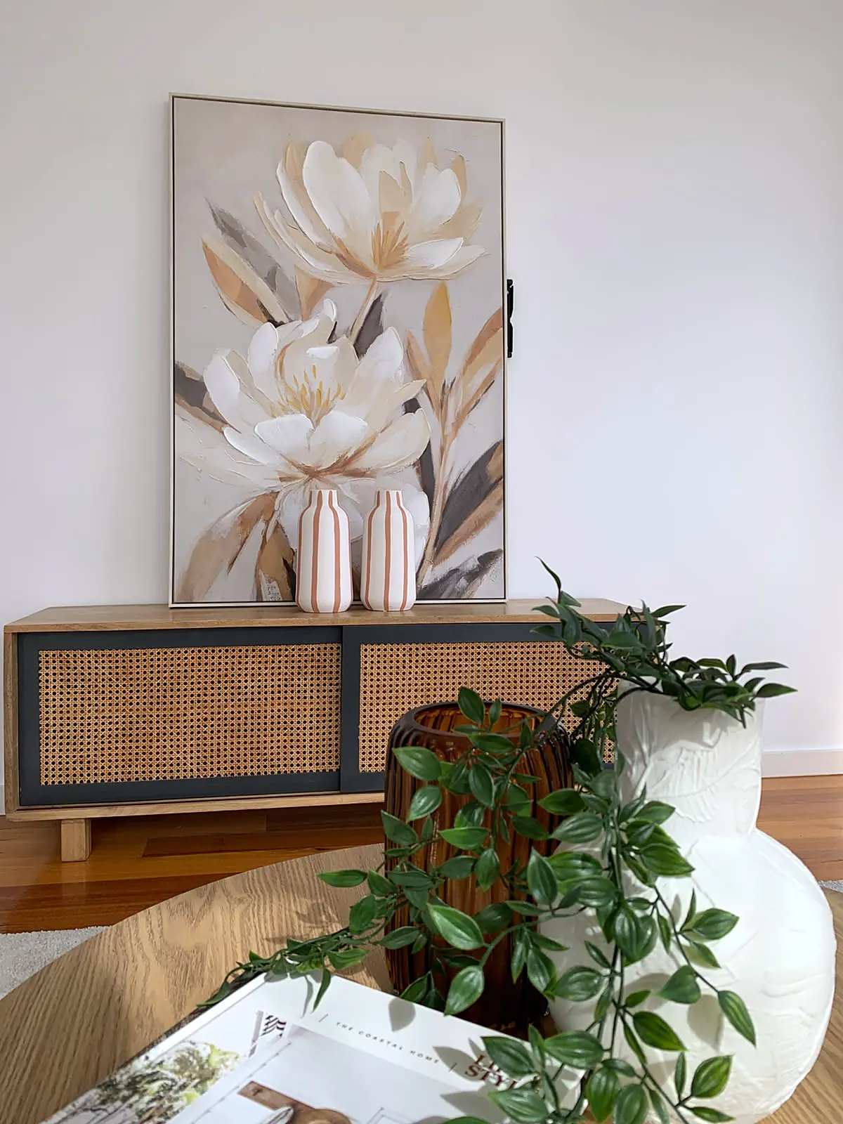 Floral artwork above a cane sideboard in a staged Footscray living room