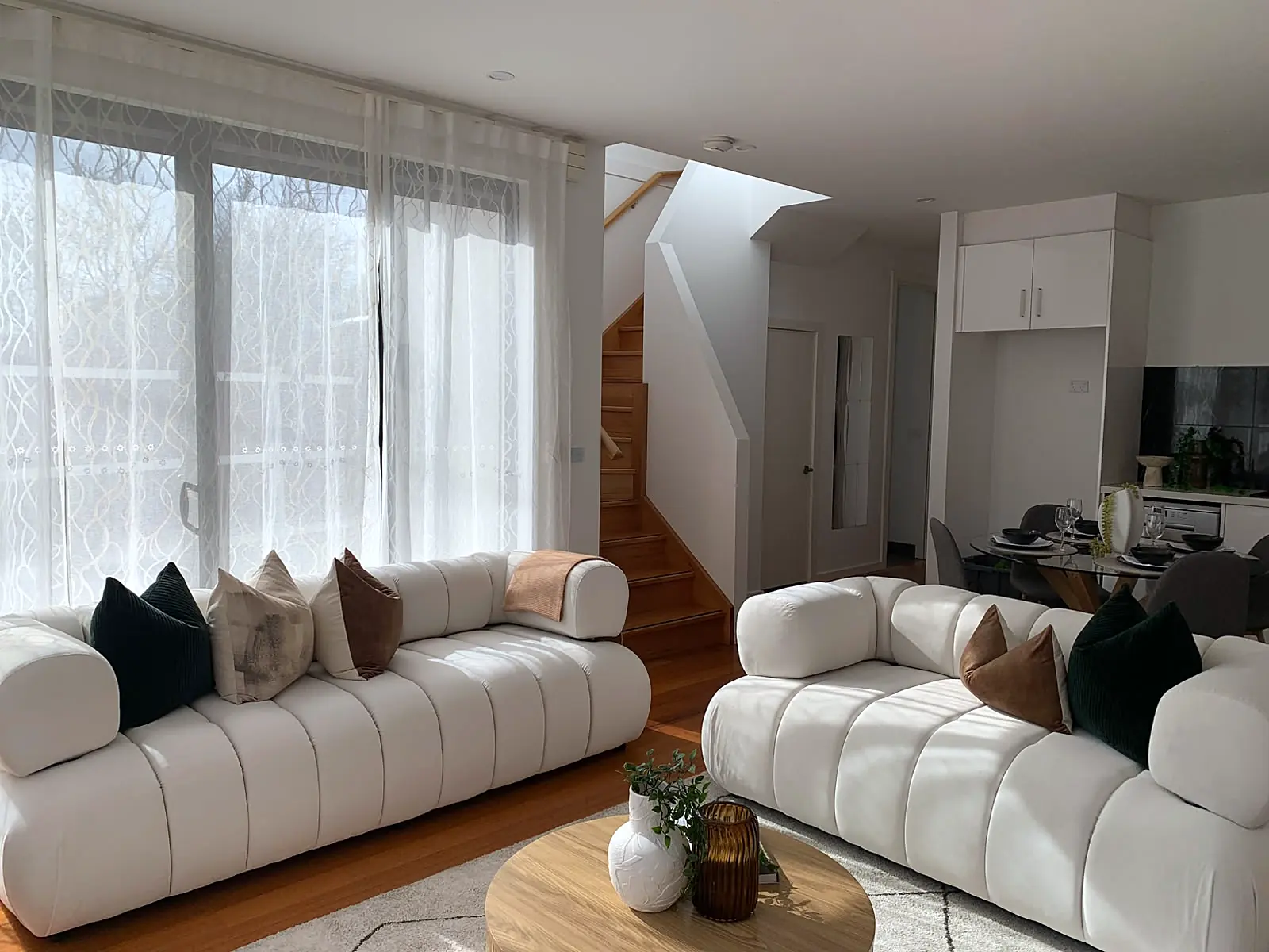 Living room staged with cream channelled sofas on timber floors in a Footscray townhouse