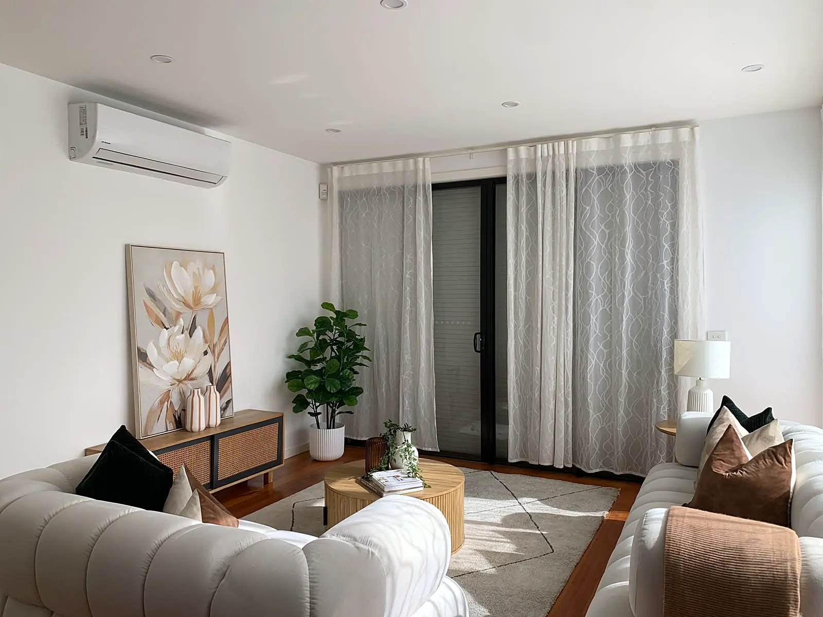 Staged living room with floral artwork and sheer curtains in a Footscray townhouse