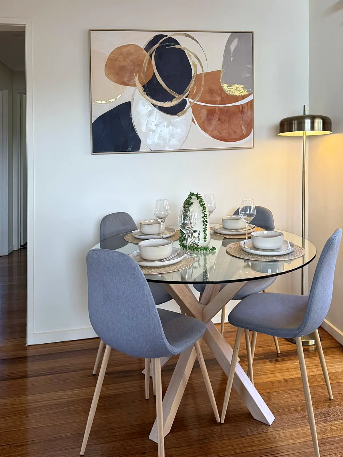 Dining nook staged with round glass table on timber floors in Frankston