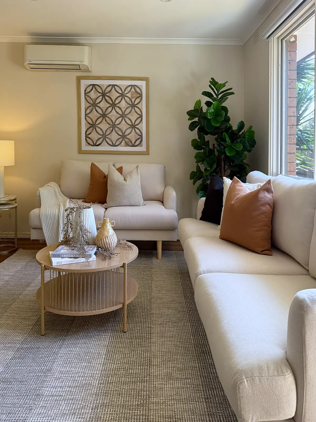 Staged living room with cream sofas and round coffee table in a Frankston home
