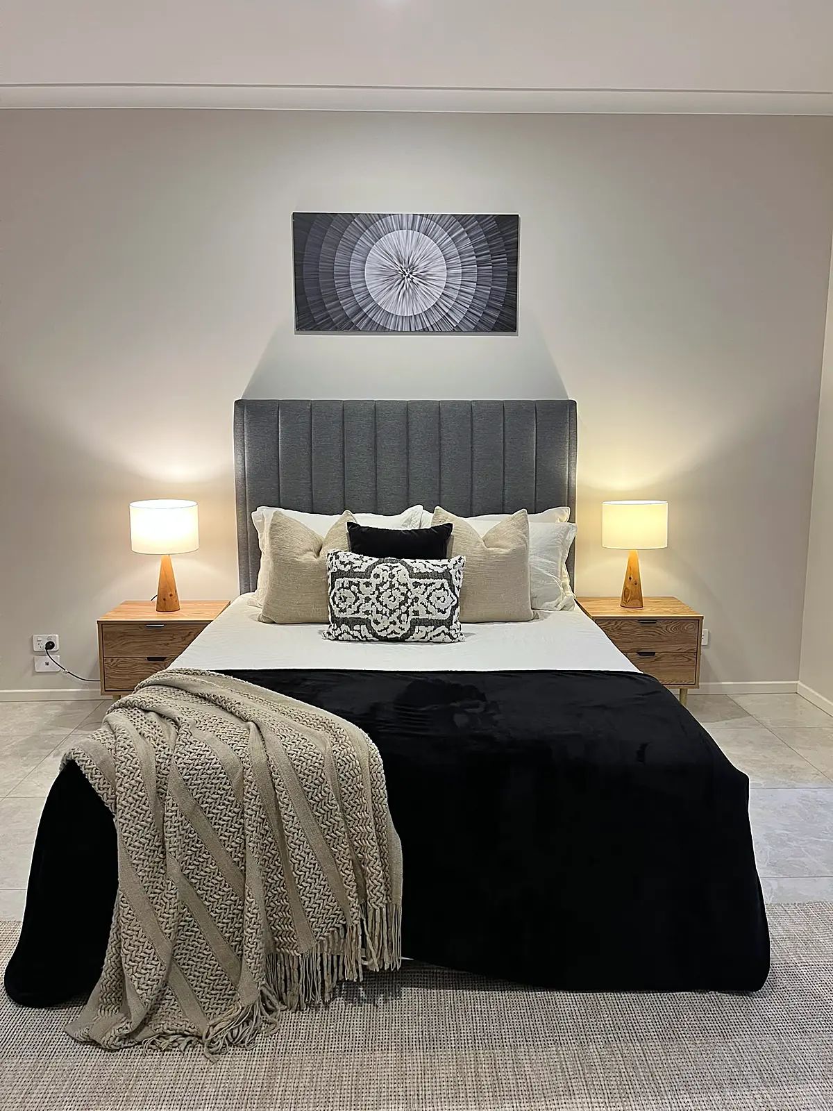 Bedroom styled with black throw and patterned cushions in a Fraser Rise home