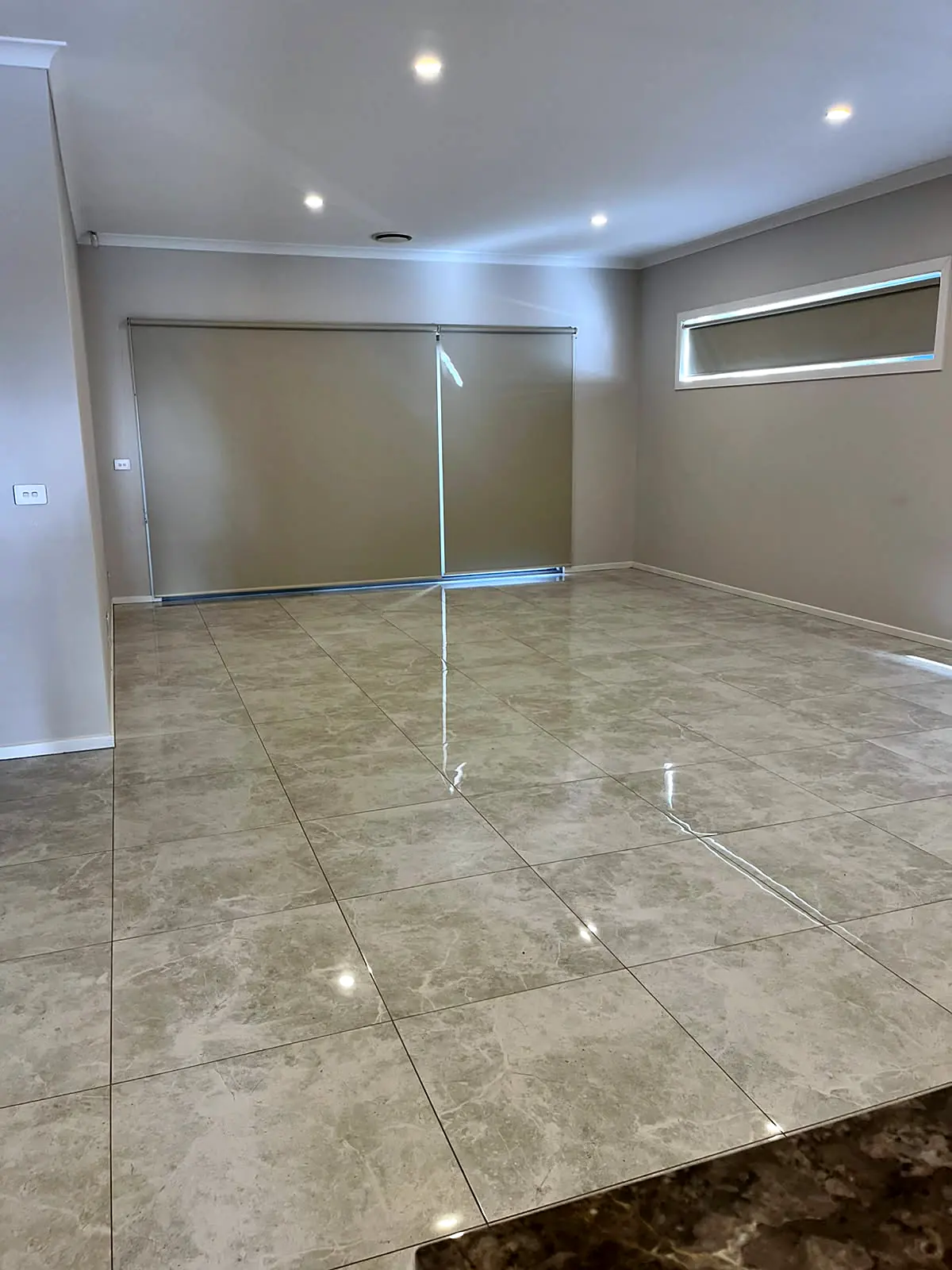 Empty open-plan living area with tiled floor before staging in a Fraser Rise home