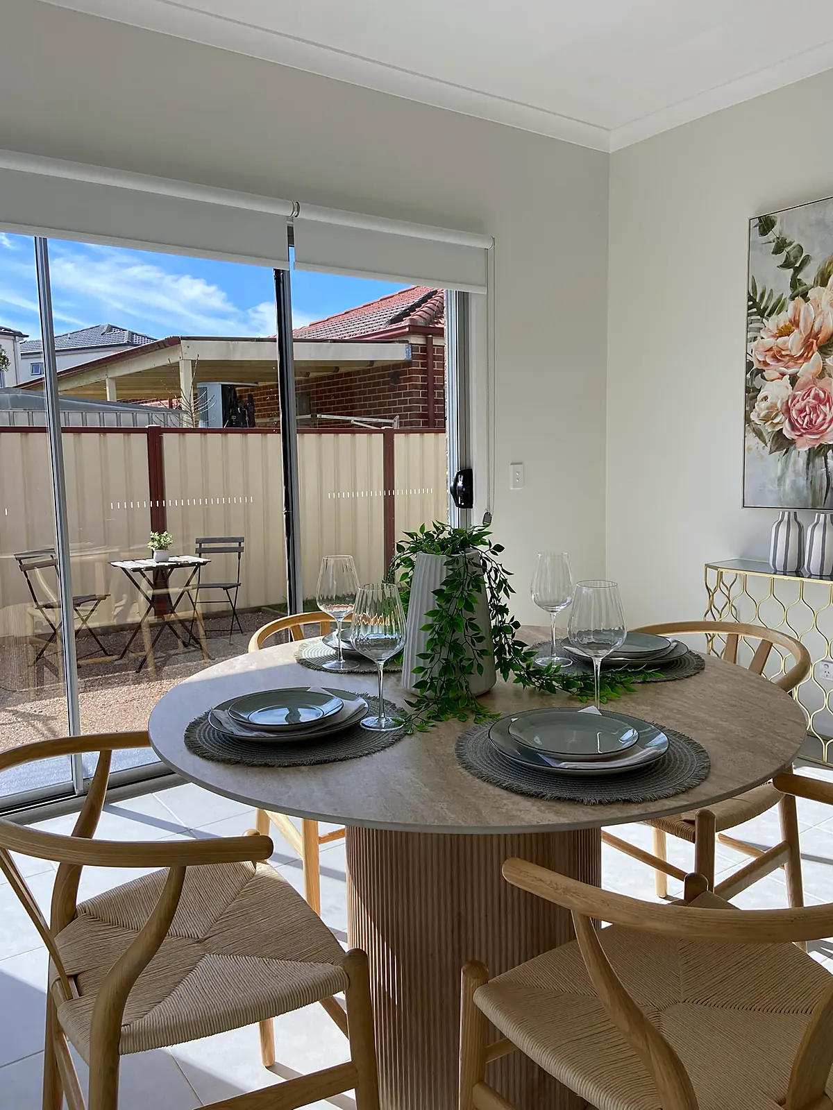 Dining table set for four with a view to the yard in a staged Harkness home
