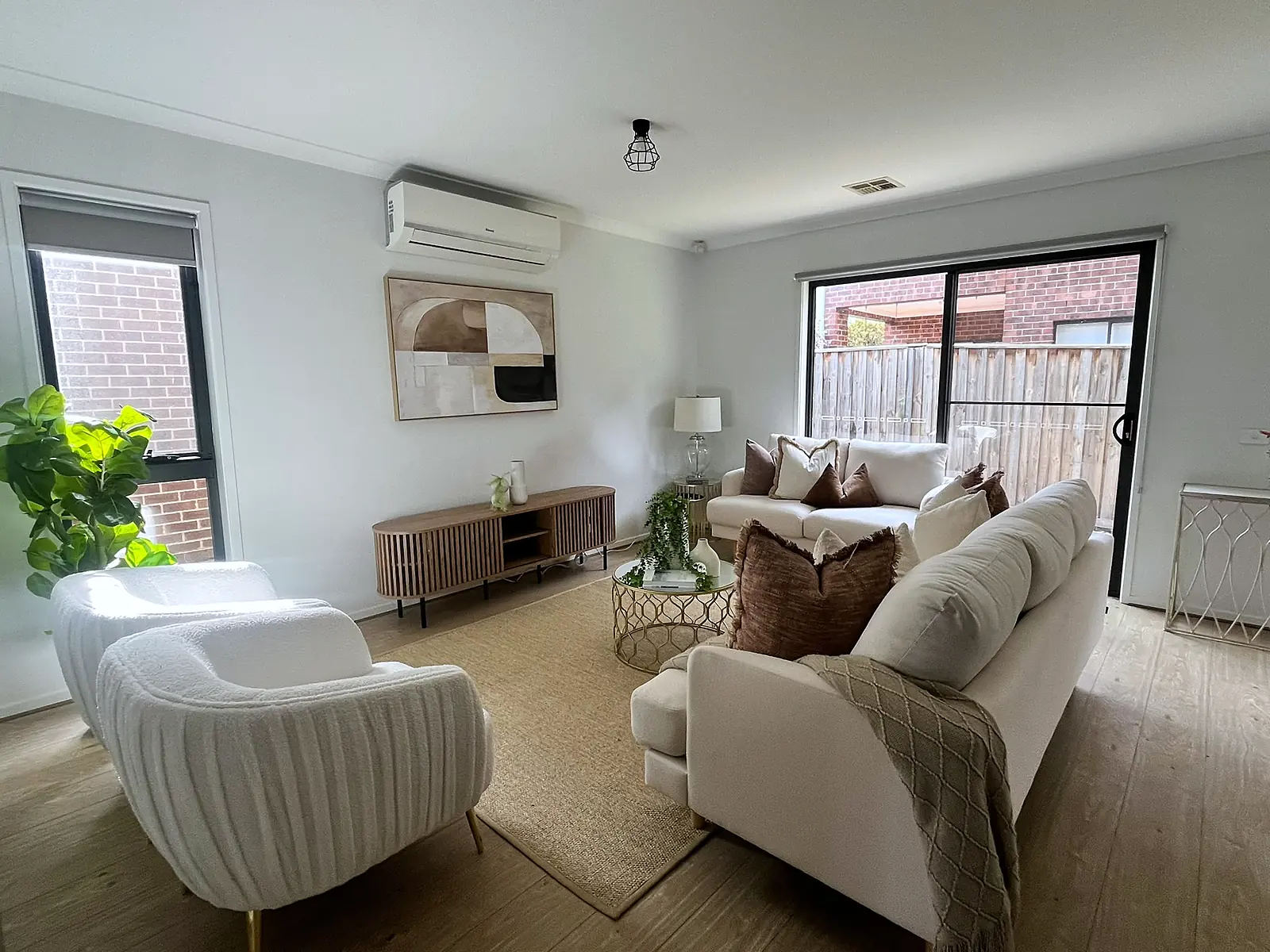 Living room staged with cream sofas, armchair and jute rug in a Hillside home