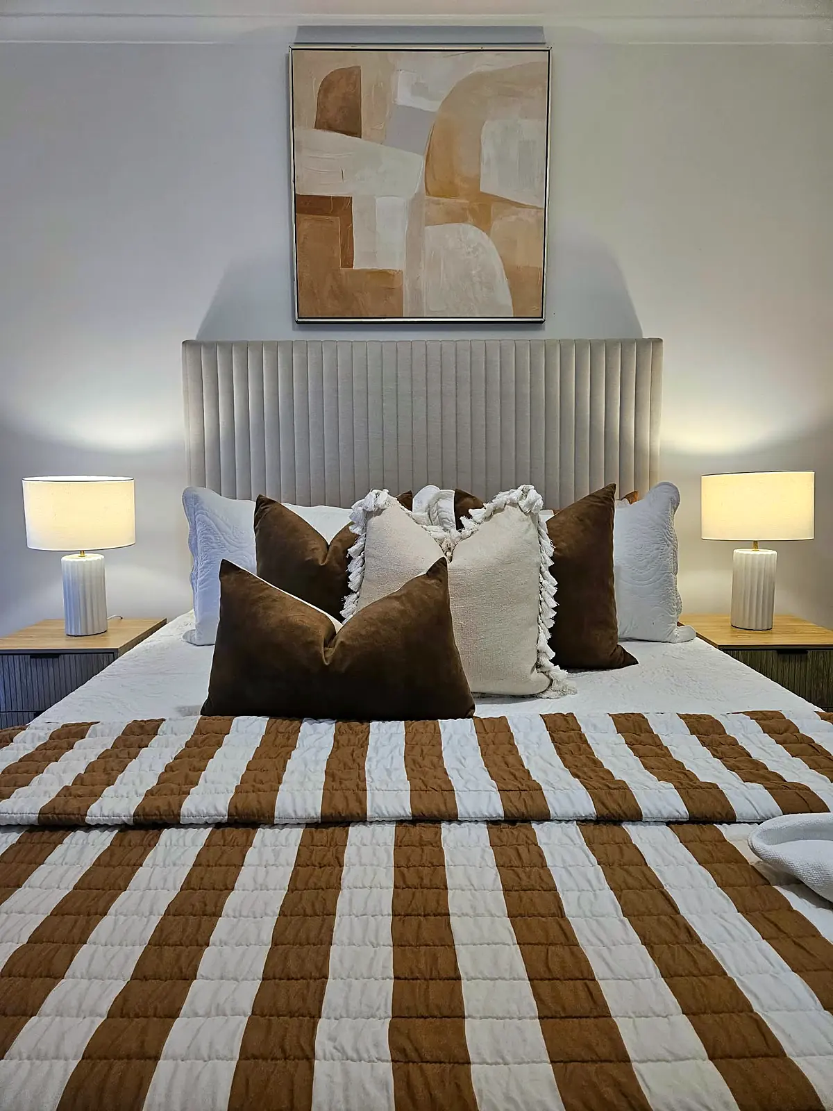 Bedroom styled with striped quilt and upholstered bedhead in a Hoppers Crossing home