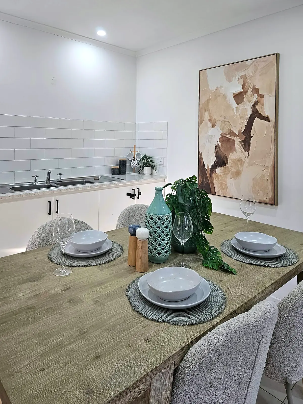 Dining area staged with timber table and artwork beside the kitchen in Hoppers Crossing