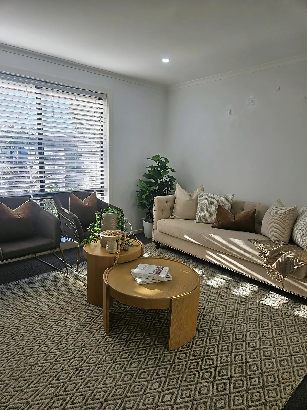 Living room styled with sofa, armchairs and patterned rug in a Hoppers Crossing home